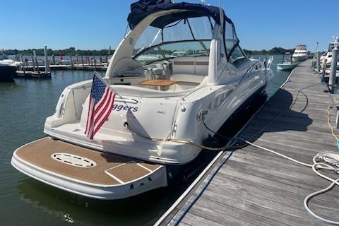 2005 Sea Ray Sundancer 320 docked, featuring a sleek design and American flag.