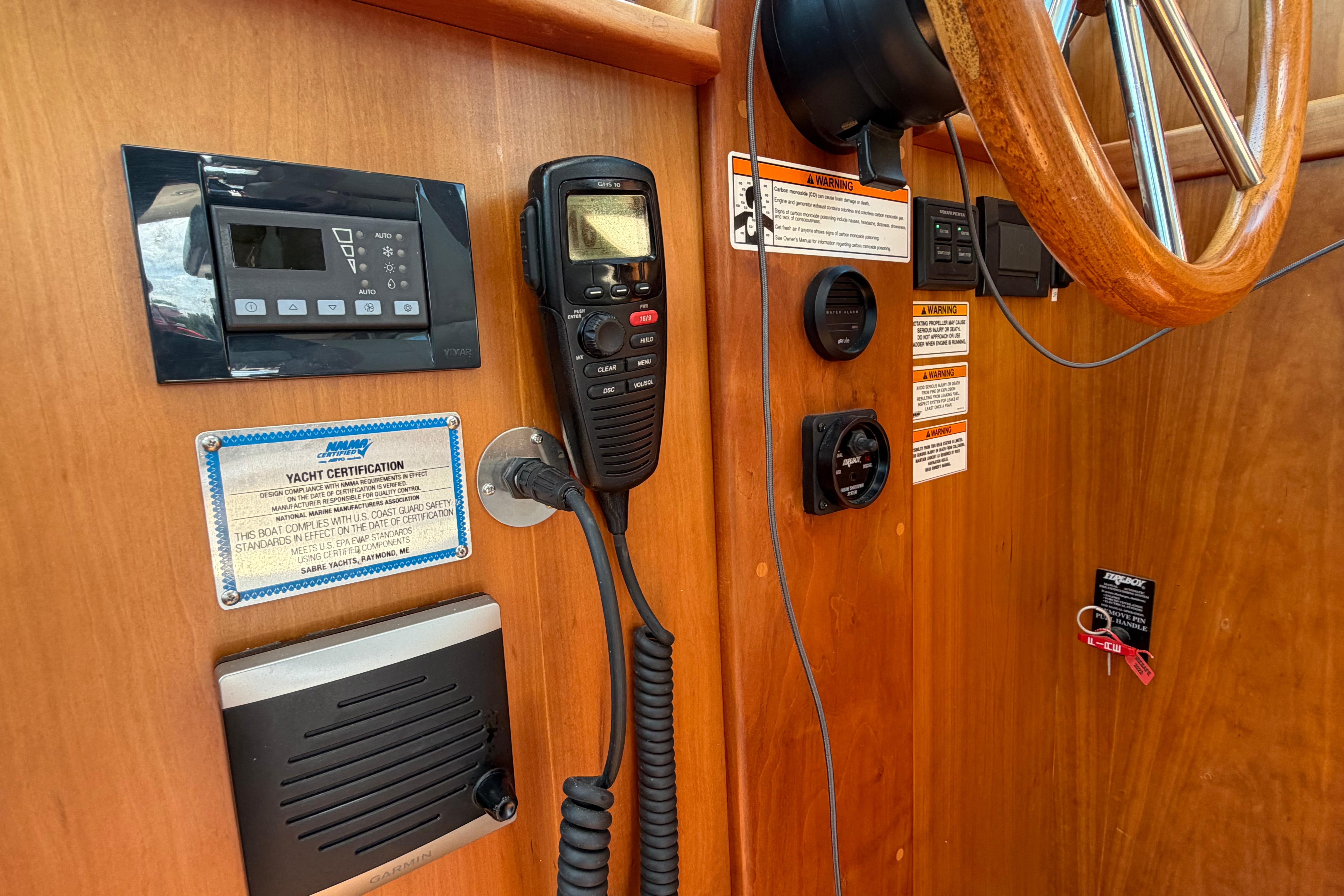 2015 Sabre 38 Salon Express helm with controls, radio, and certification plaque.
