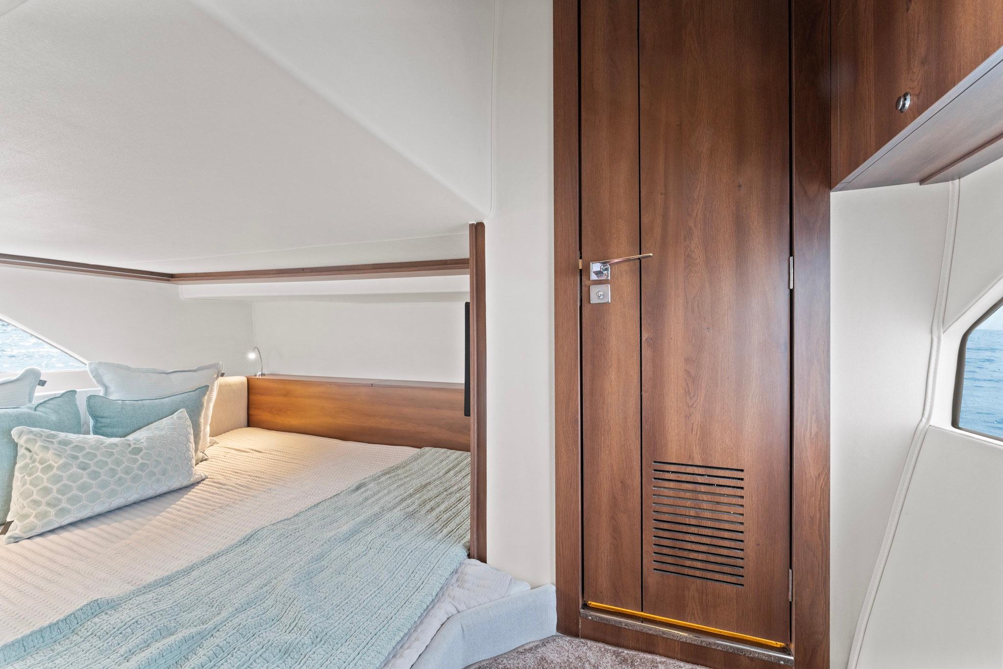 Luxurious cabin interior of 2025 Valiatt 380GT yacht with cozy bedding and wooden accents.