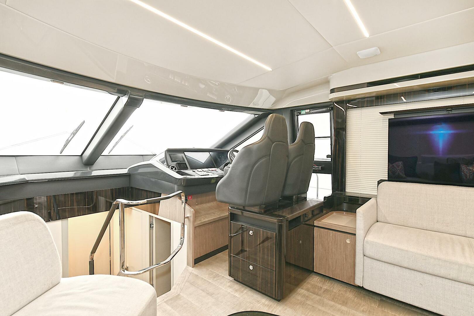 Luxurious interior of 2022 Absolute 62 Fly yacht with modern seating and navigation area.
