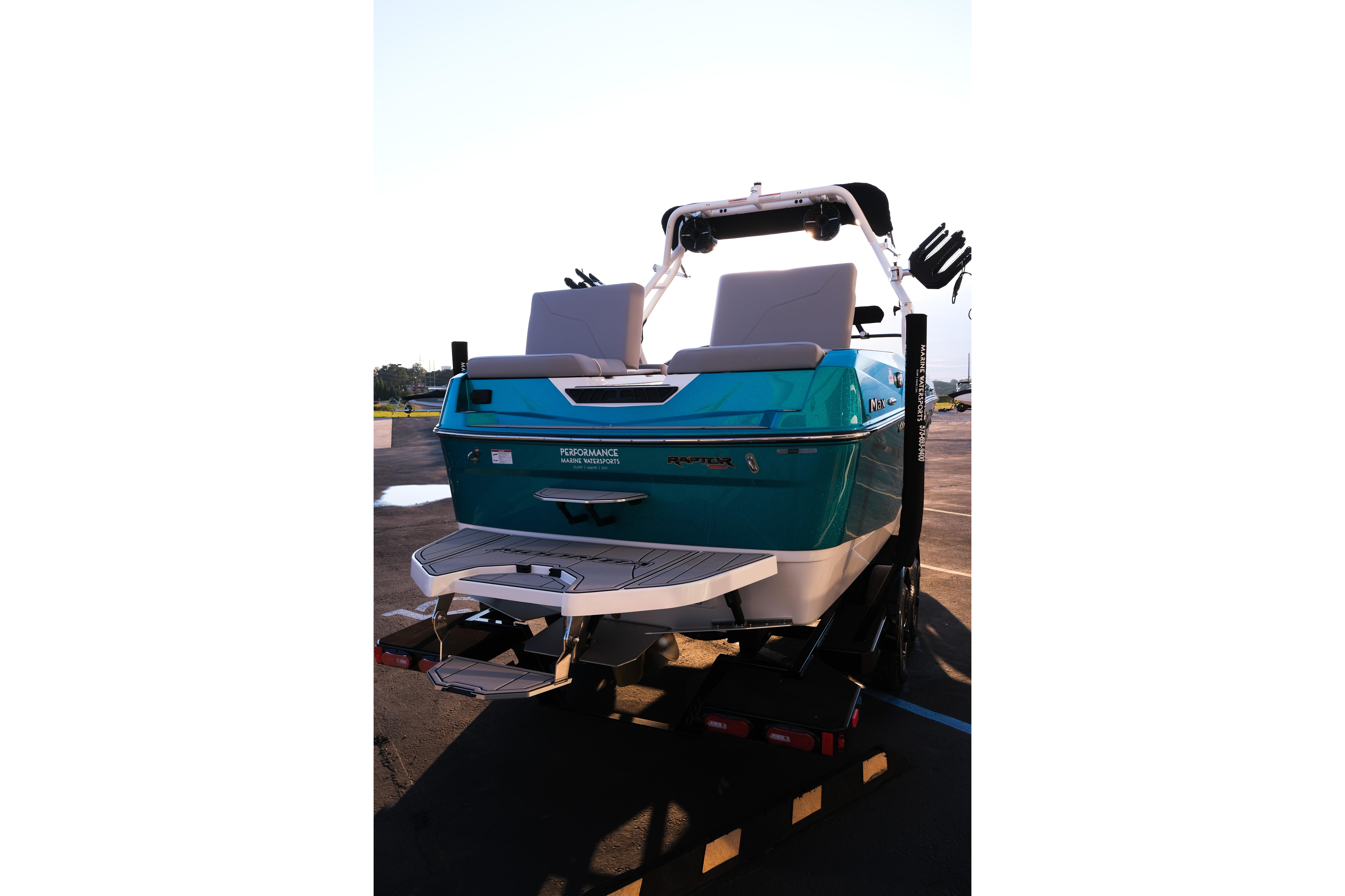 2026 Moomba Max boat, teal color, rear view on trailer, outdoor setting.