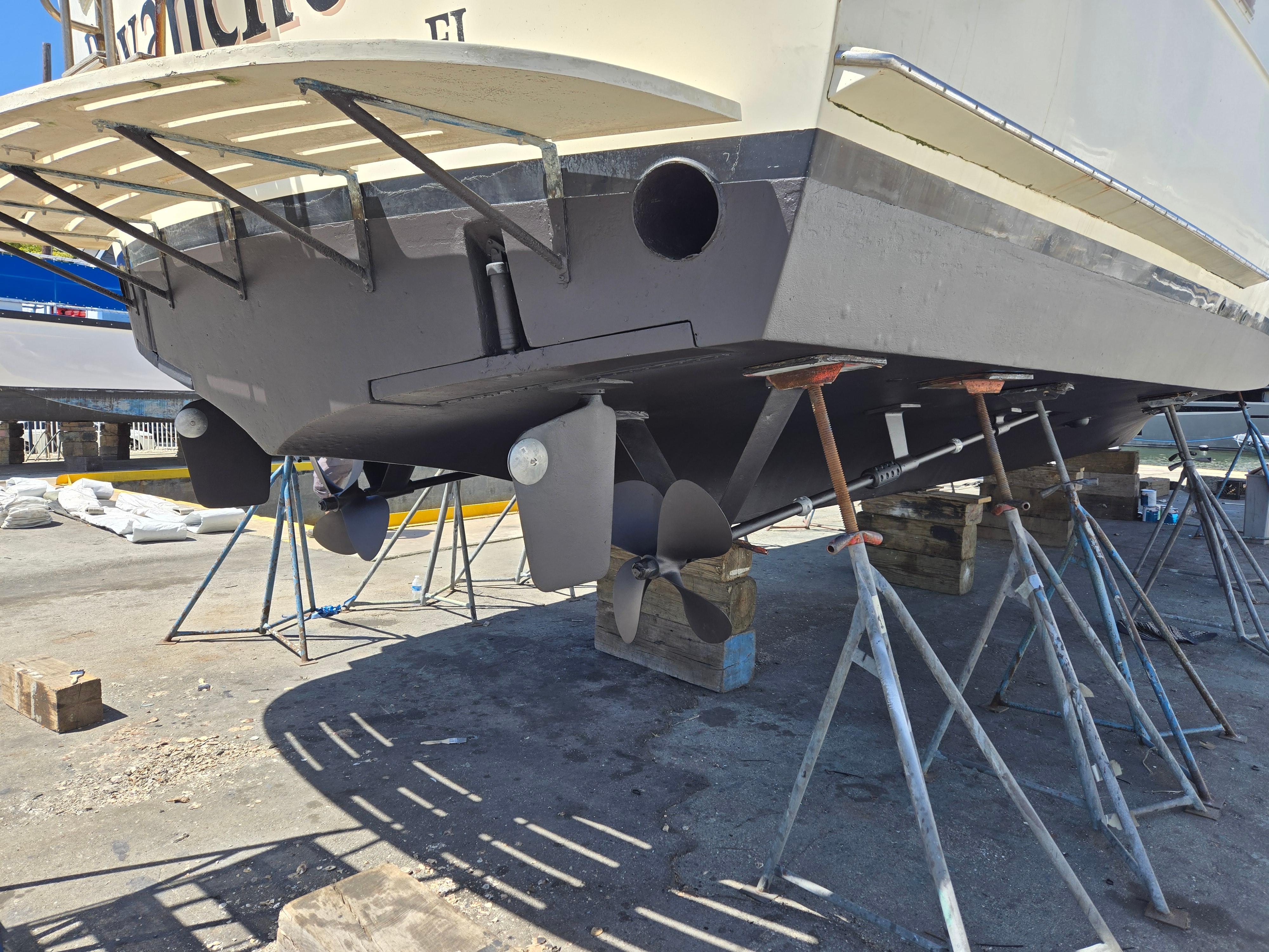 1986 Hatteras 53 Extended Deckhouse yacht on dry dock, showing propellers and hull.