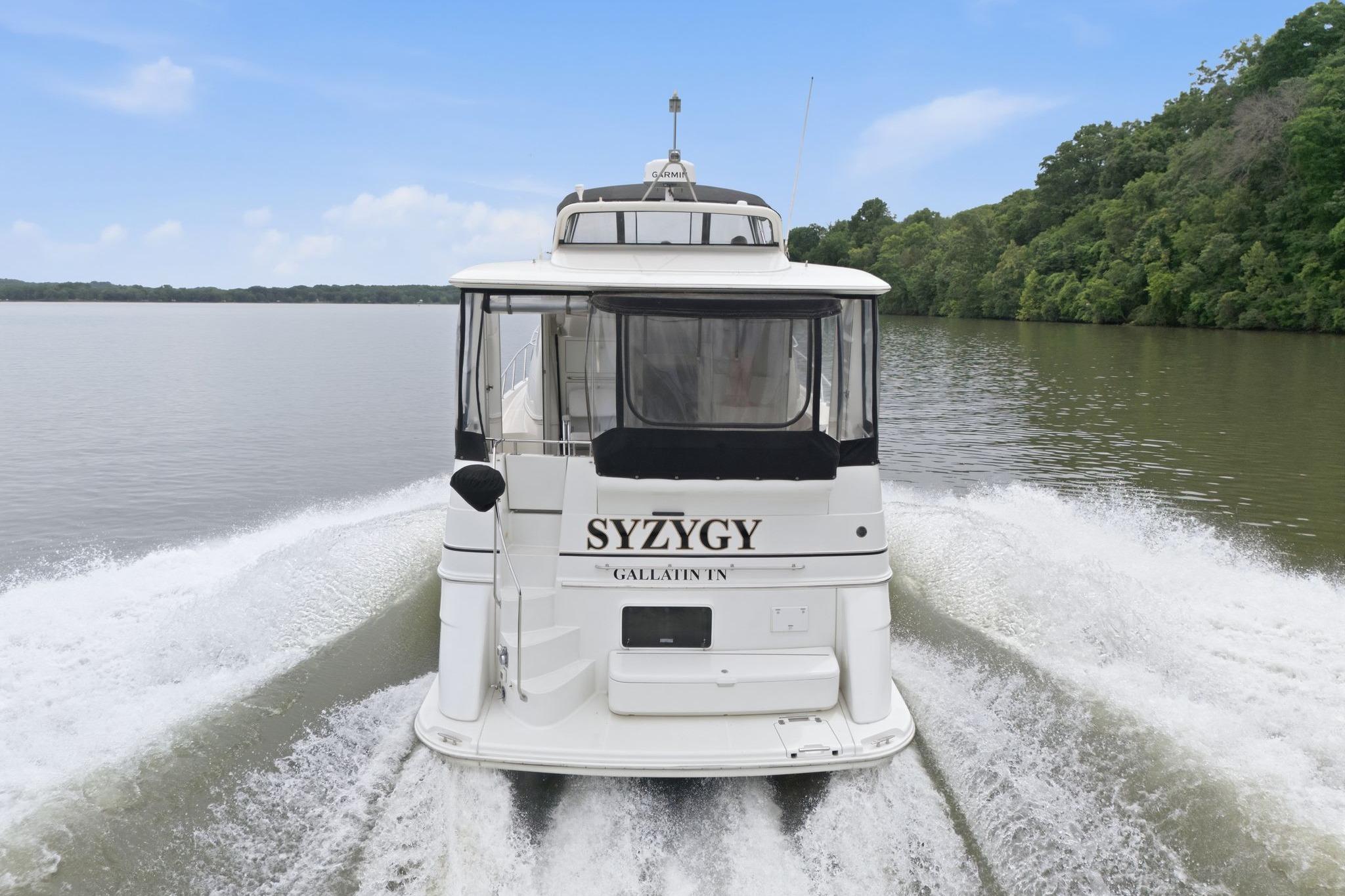 2005 Carver 39 Motor Yacht cruising on a serene river with lush green surroundings.