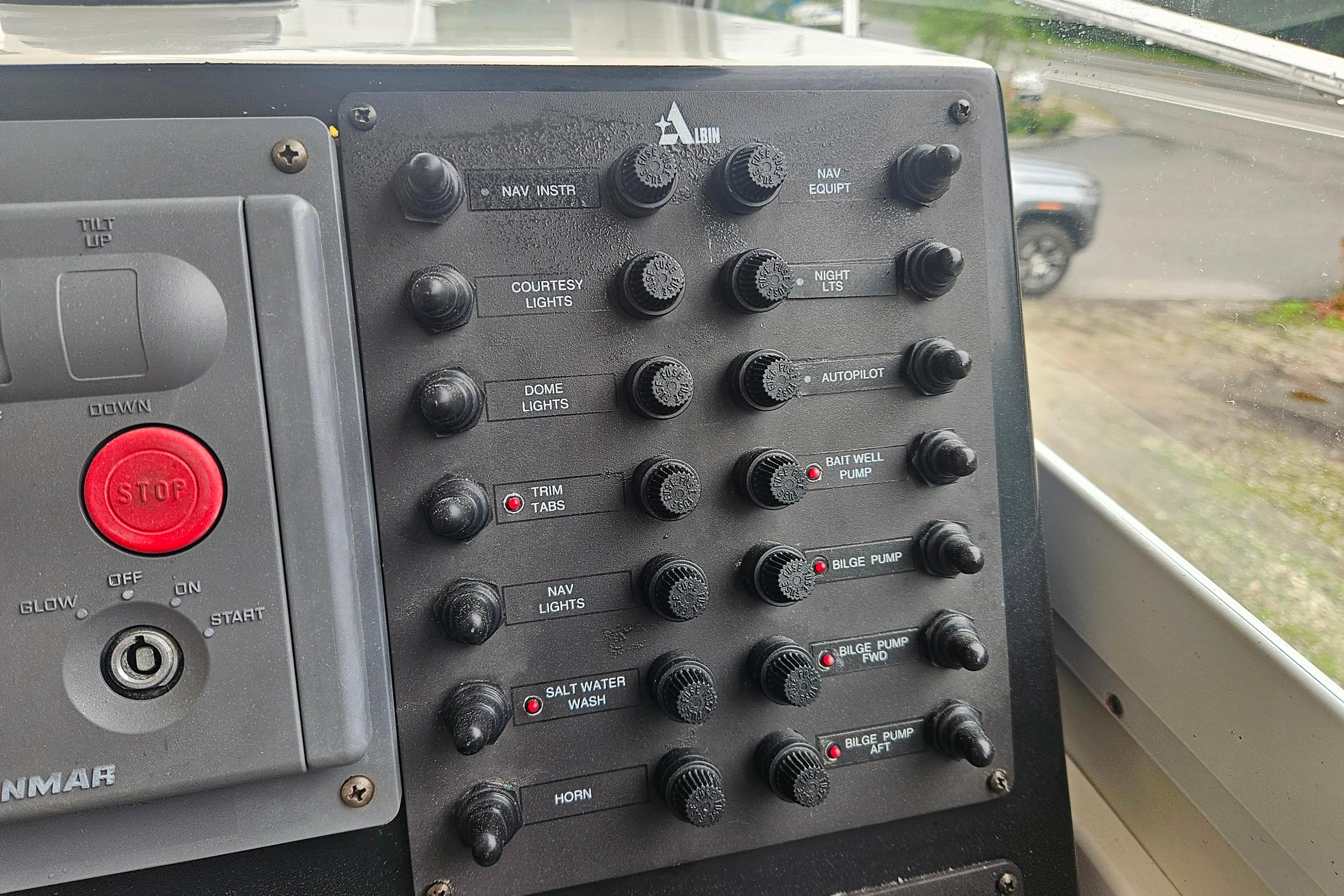 Control panel of a 1999 Albin 28 Tournament Express boat with various switches and buttons.