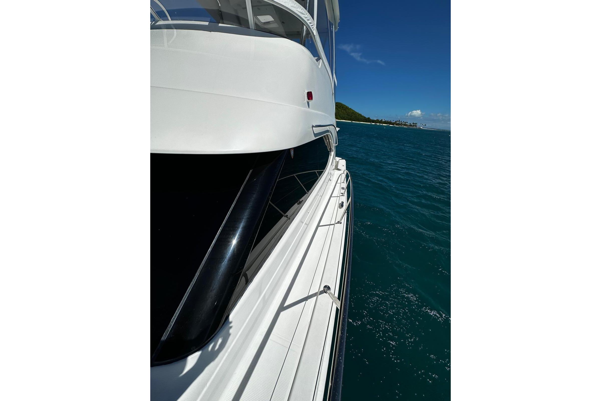 2012 Riviera 43 Flybridge yacht cruising on clear blue waters.