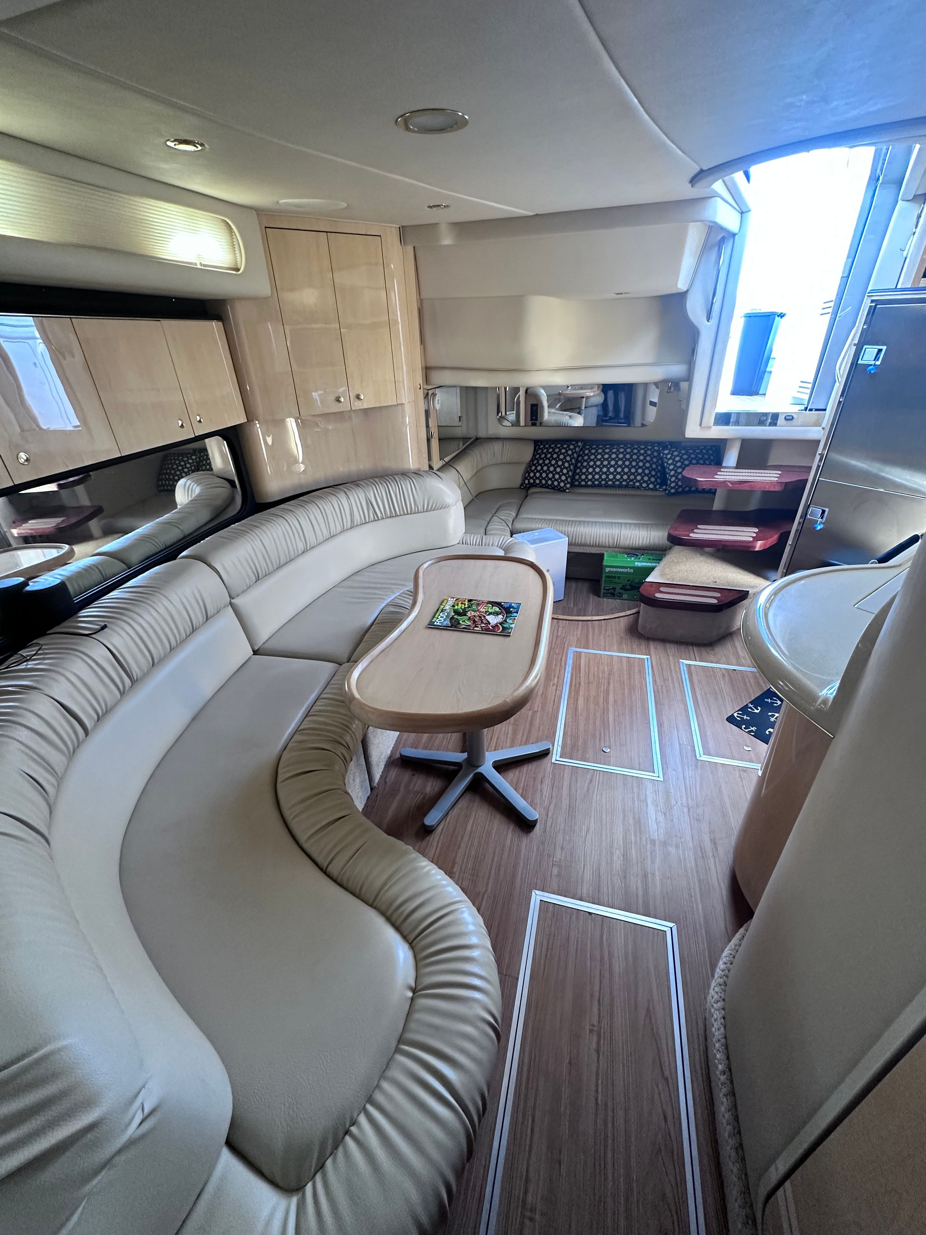 Luxurious interior of 2000 Sea Ray 380 Sundancer yacht with plush seating and wooden flooring.