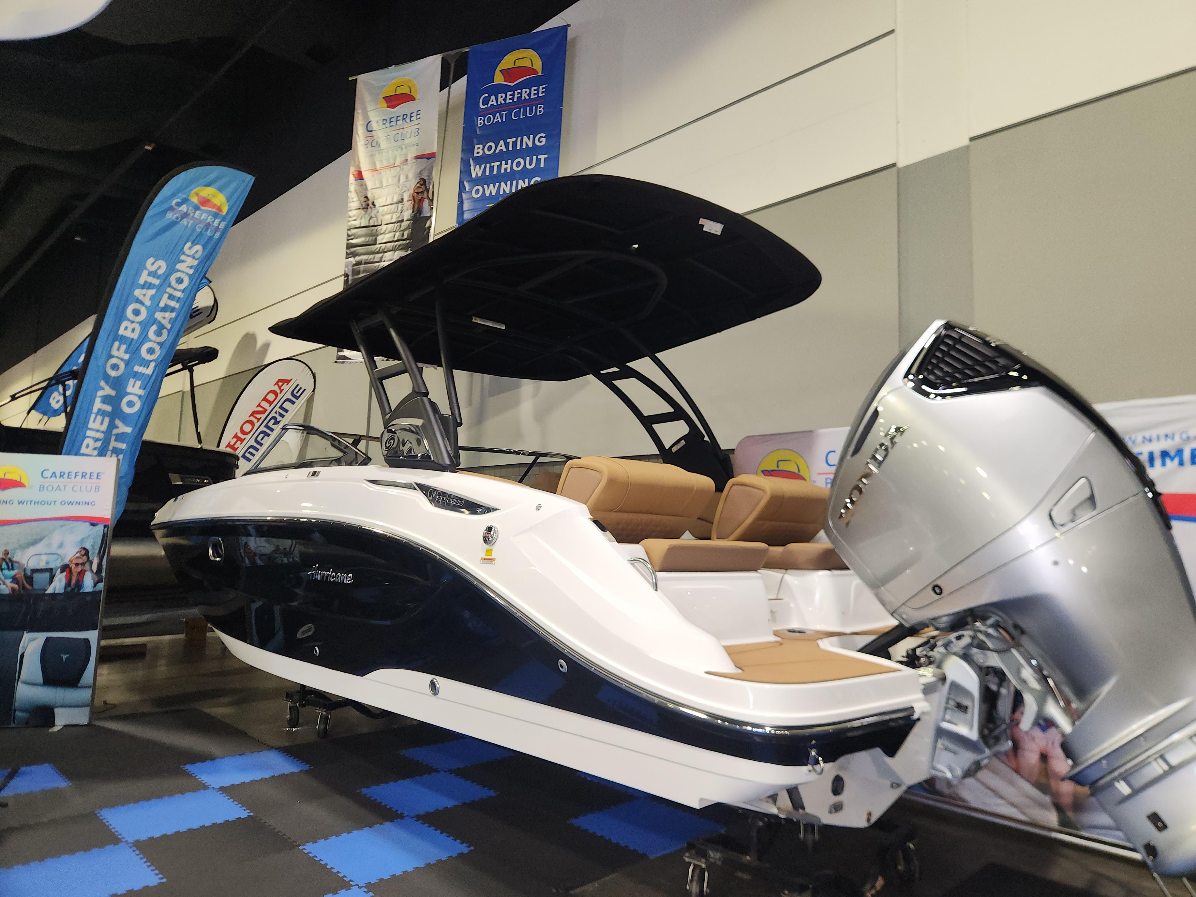2025 Hurricane SunDeck 2600 OB boat displayed at an indoor exhibition.
