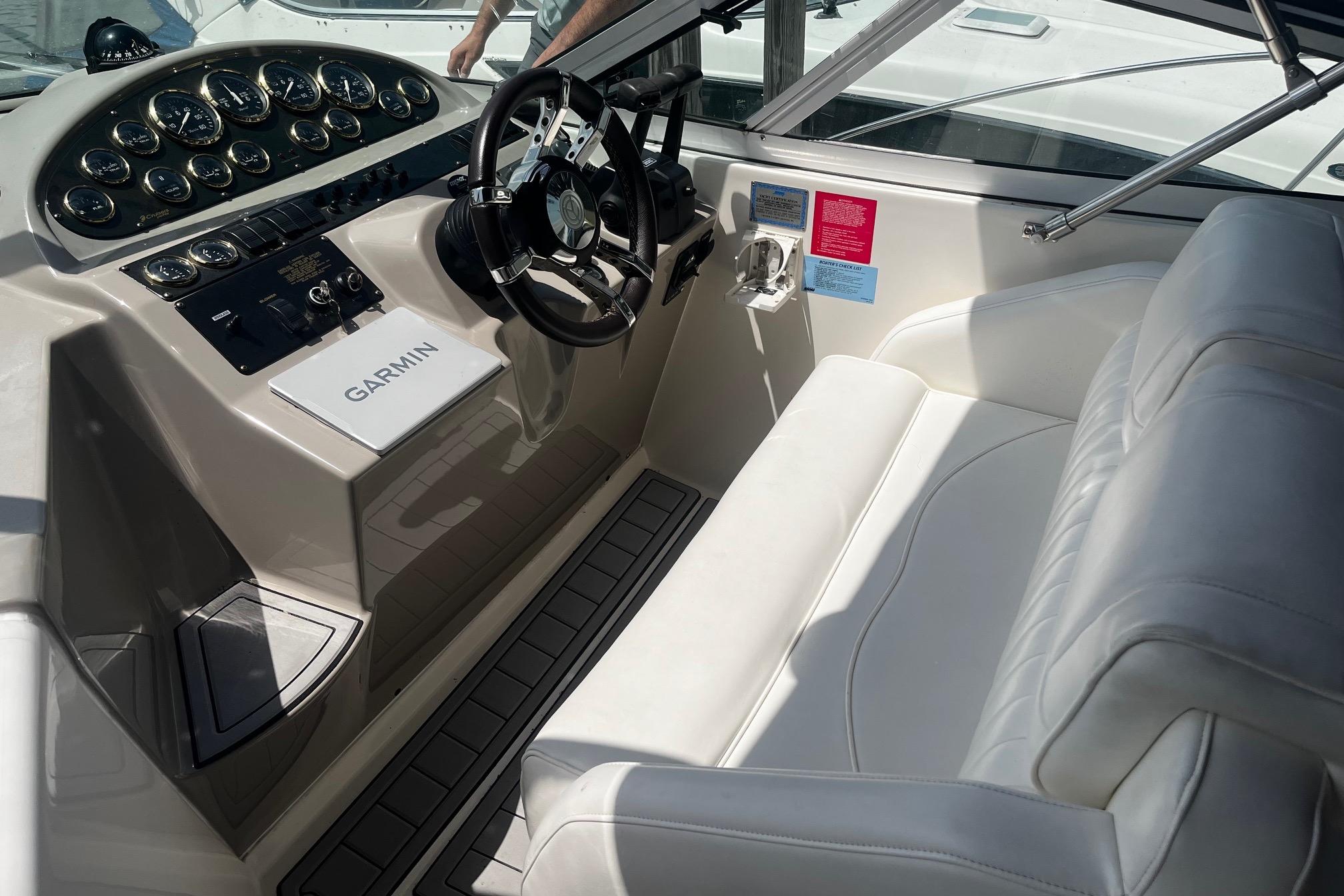 2004 Cruisers Yachts 280 CXi Express cockpit with steering wheel and Garmin navigation system.