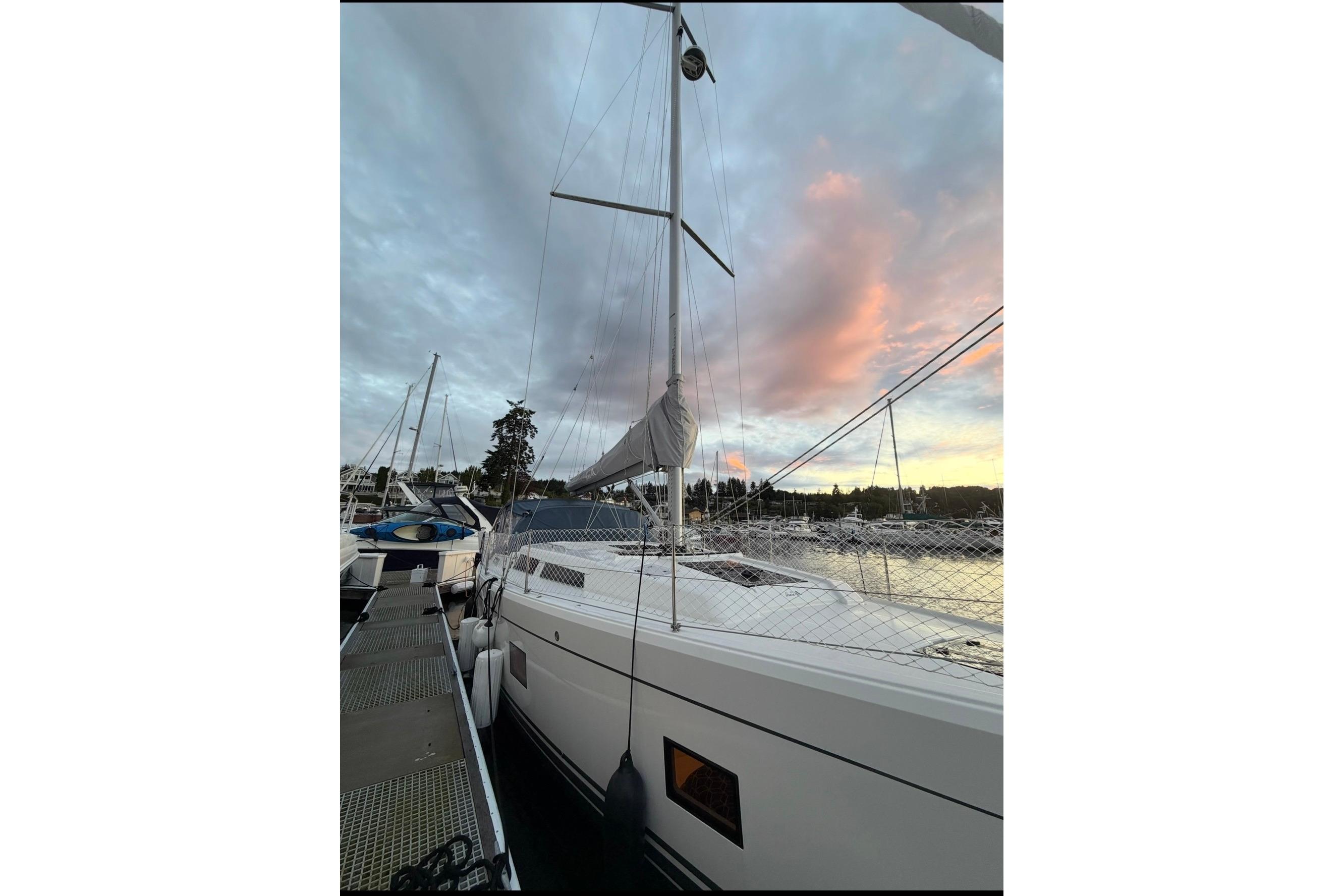 Sailing yacht Hanse 418, 2022 model, docked at sunset with vibrant sky.