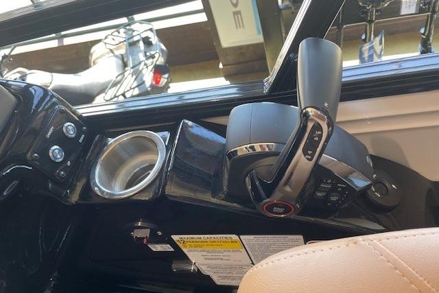 Boat control panel of 2026 Regency 230 DL with throttle and cup holder.