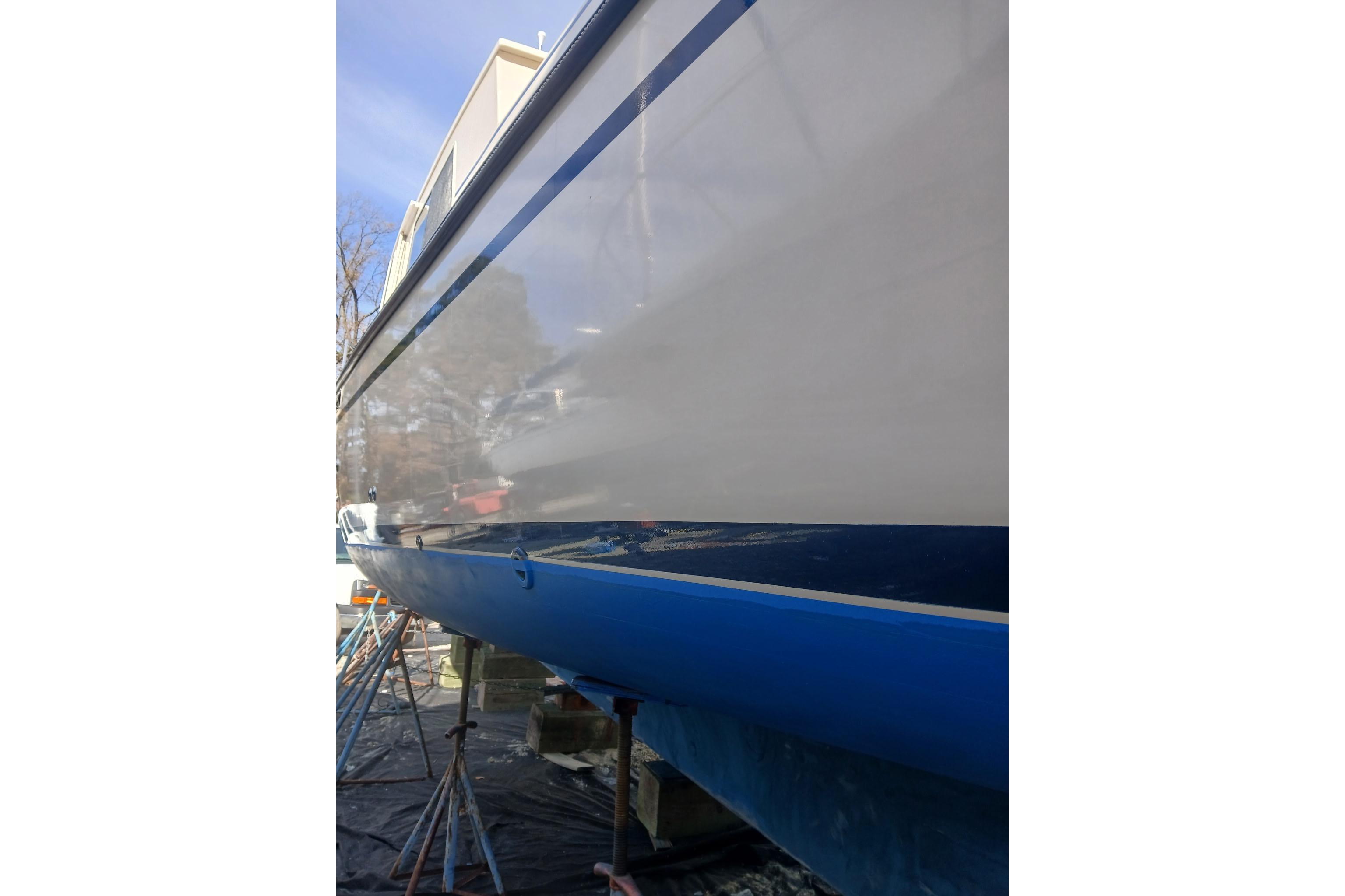 1997 Rosborough Trawler boat with blue and white hull, docked on supports.