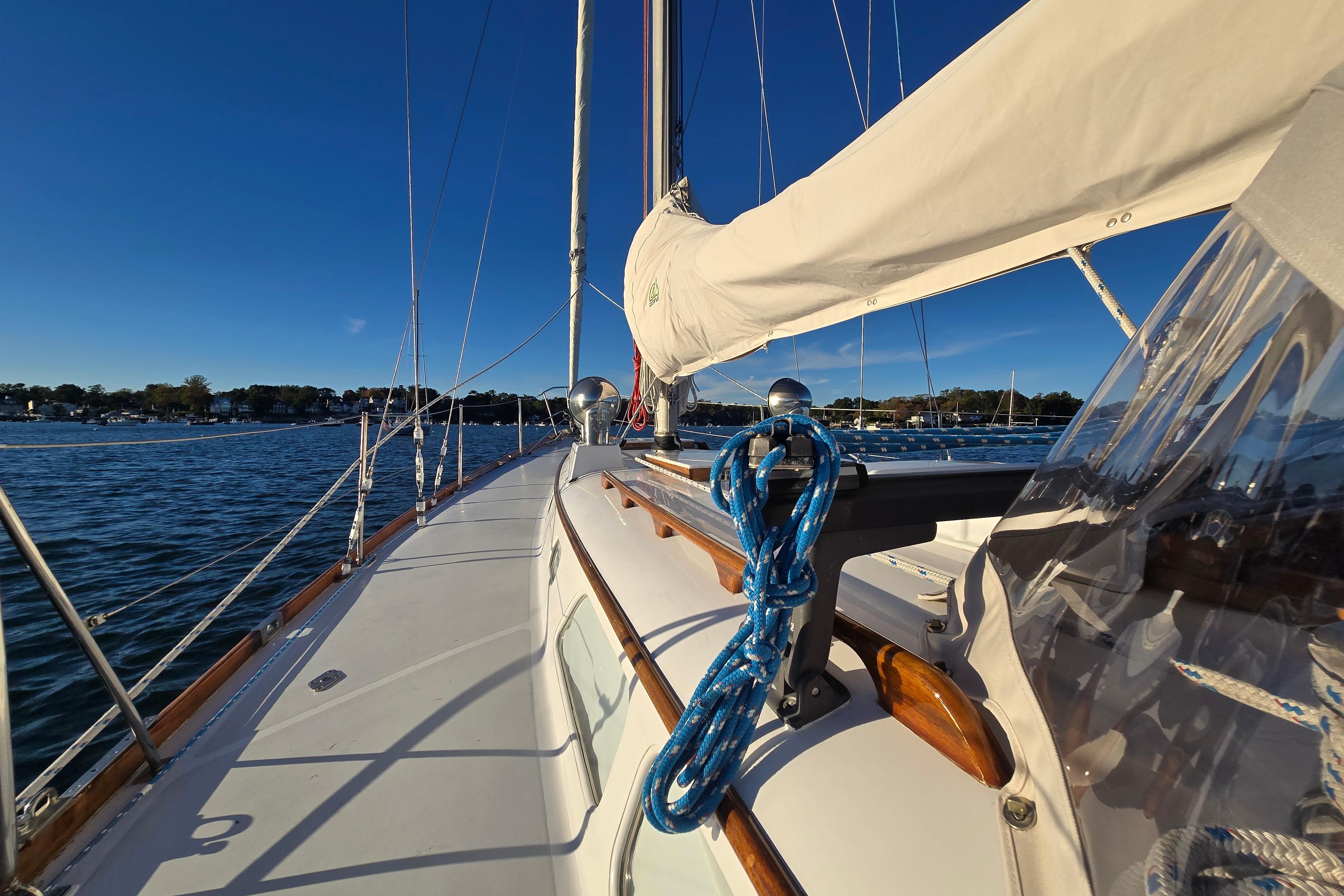 1970 Hinckley Bermuda 40 sailboat deck with blue ropes, sailing on calm waters.