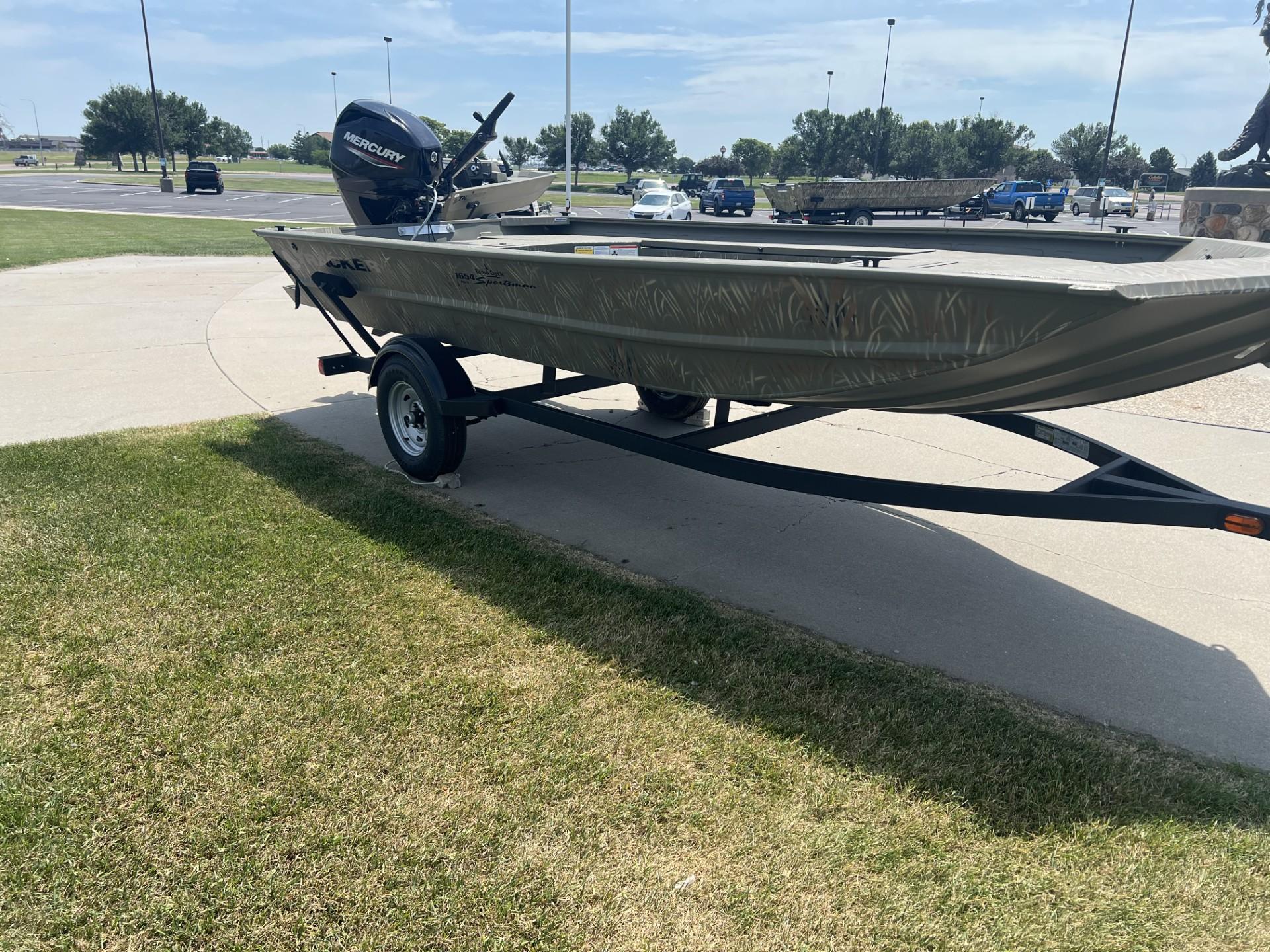 2025 Tracker Grizzly 1654 T Sportsman boat on trailer, parked outdoors on sunny day.