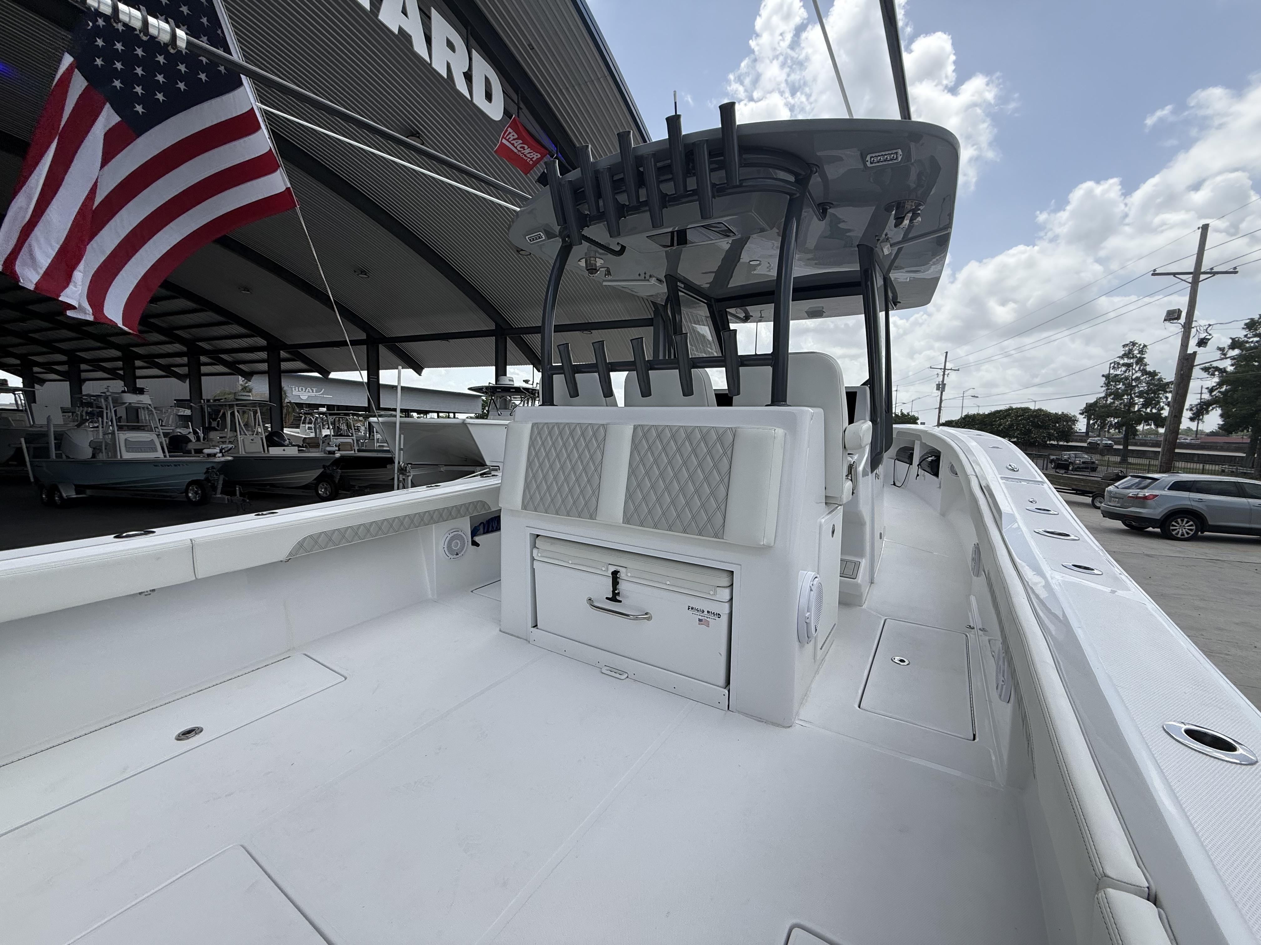 2024 Front Runner 39 CC boat with American flag, docked under a covered area.