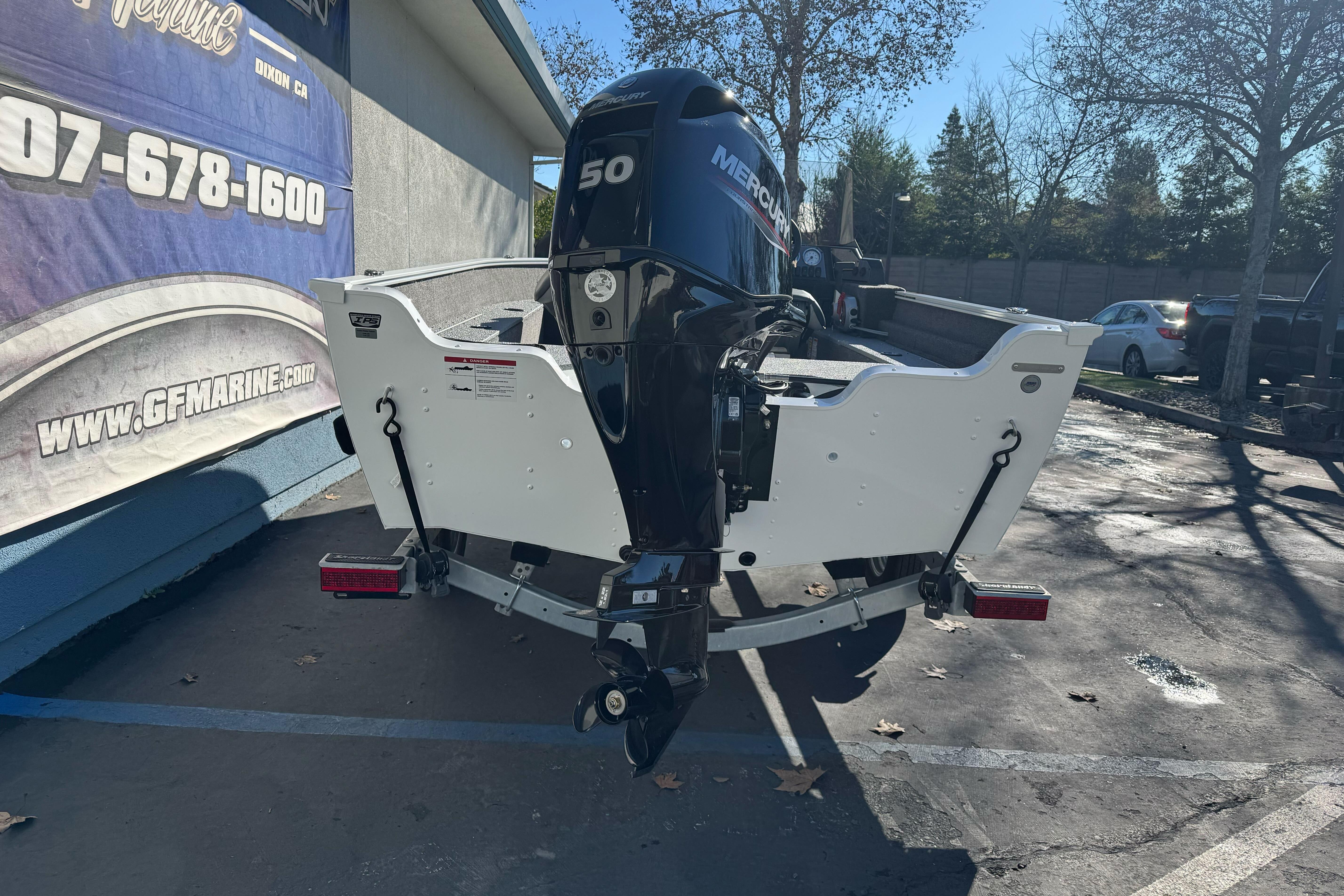 2026 Lund 1650 Angler SS boat with Mercury 50 engine, parked outdoors.
