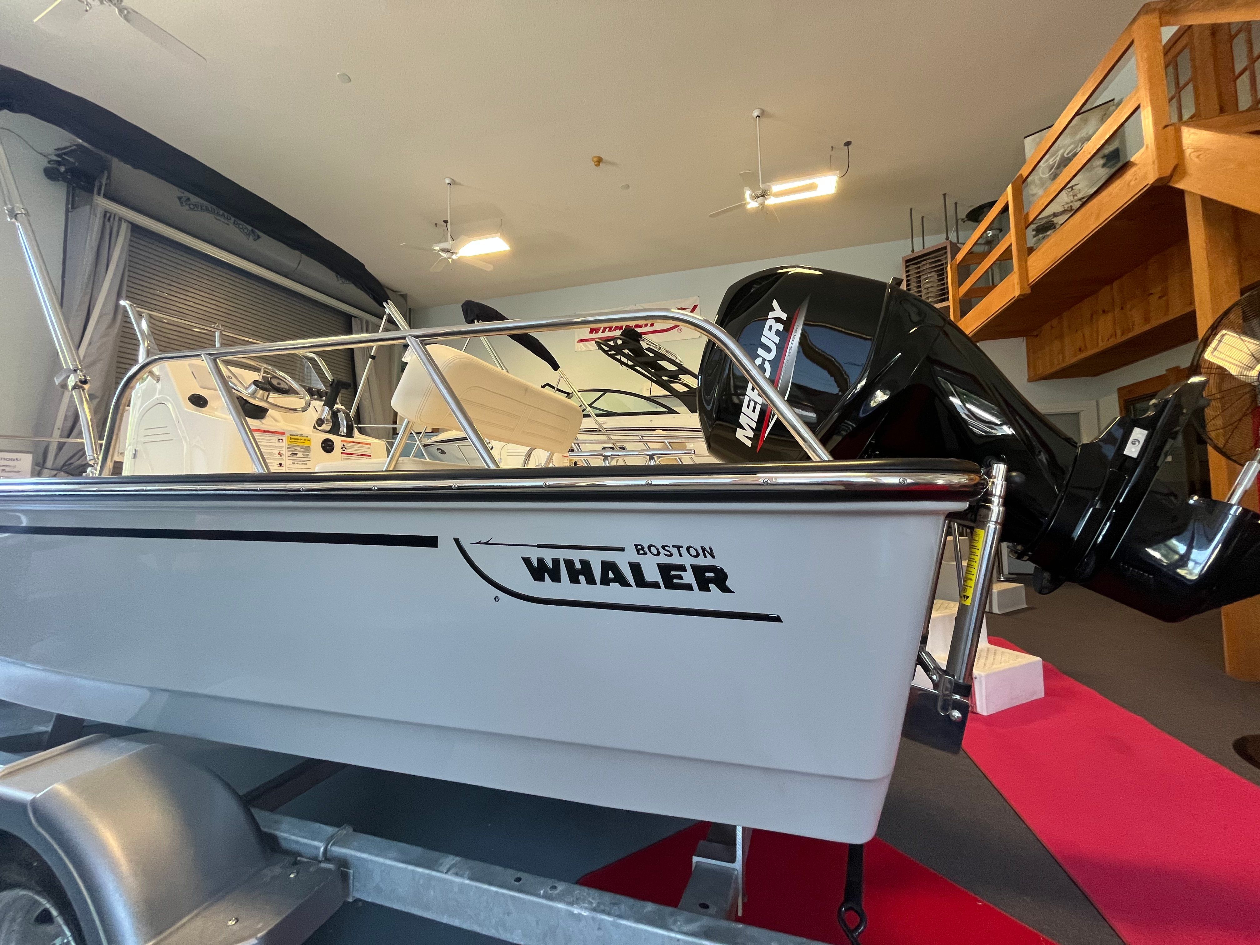 A 2026 Boston Whaler 150 Montauk sits on a trailer in a showroom.