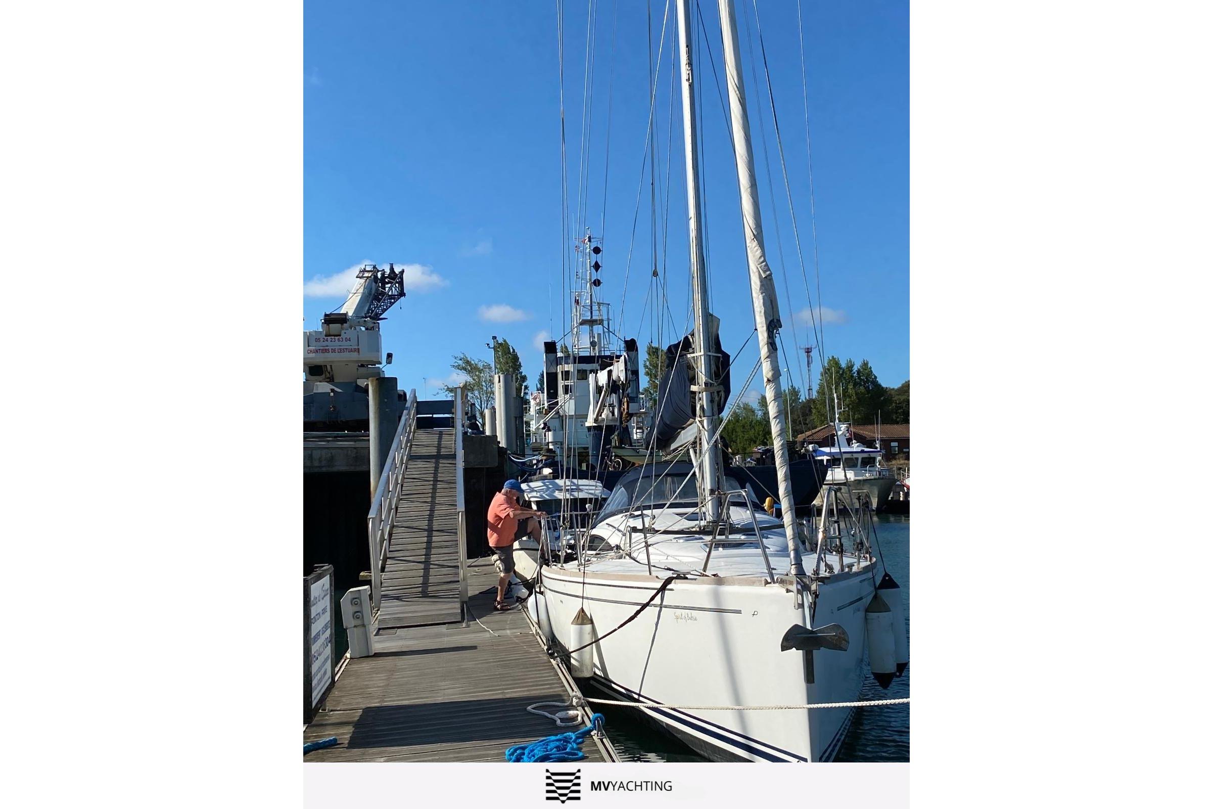 Sailboat Maxi 1300, 2010 model, docked at marina under clear blue sky.