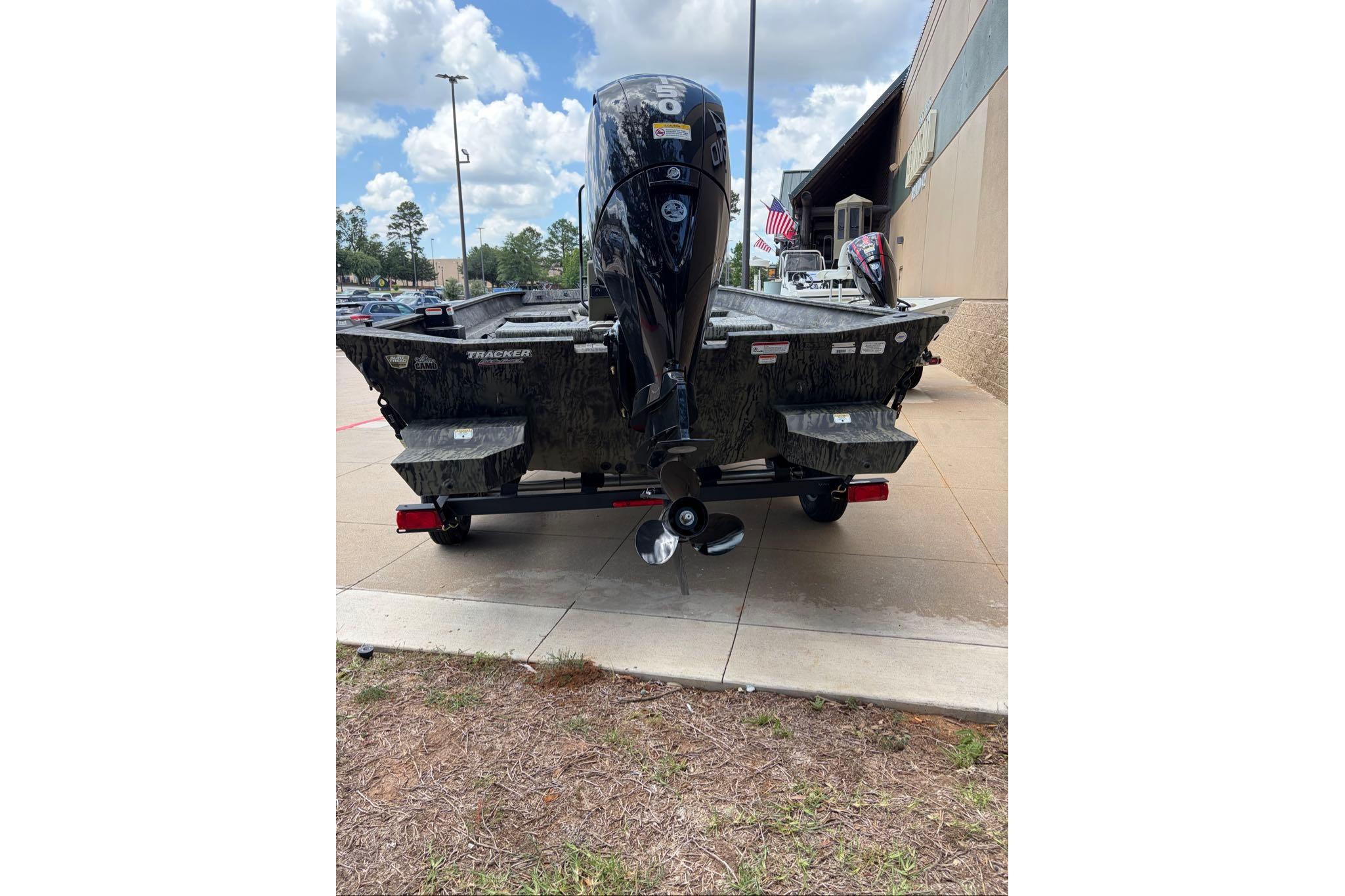 2026 Tracker Grizzly 2072 CC boat with outboard motor, parked outdoors on a sunny day.