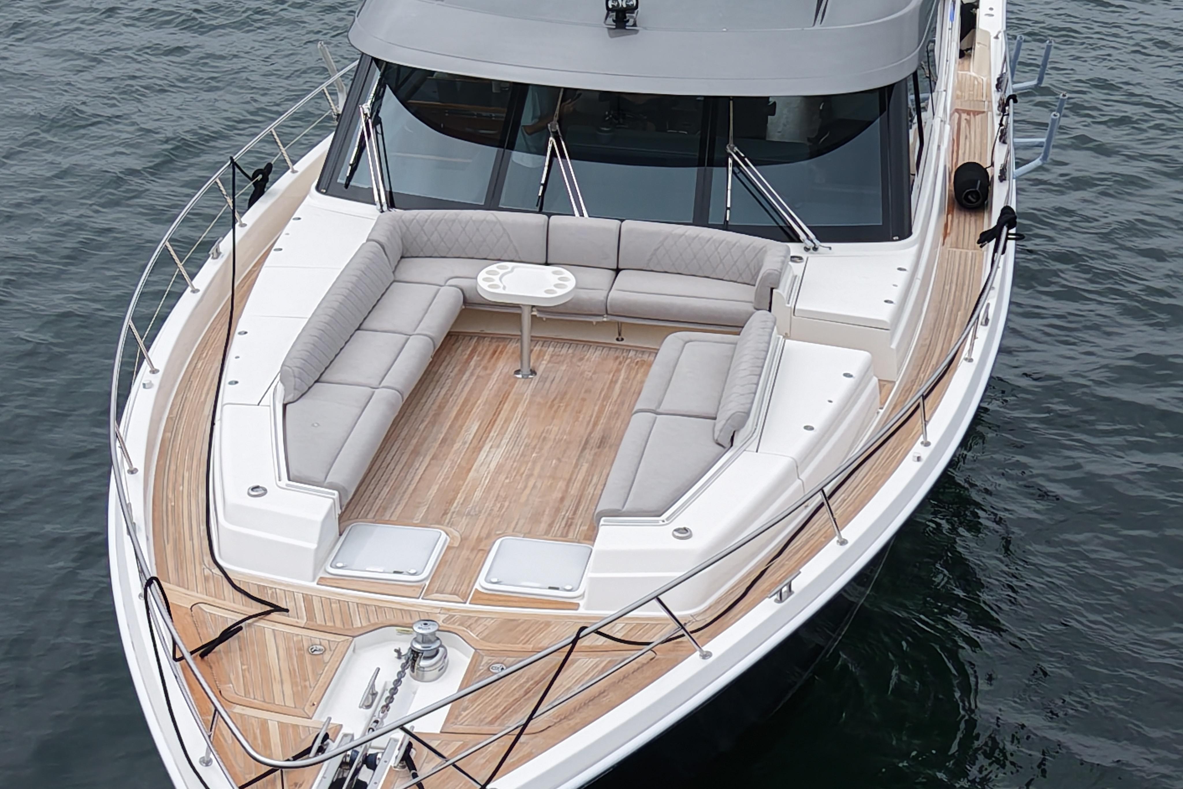 2023 Riviera 645 SUV luxury yacht with spacious deck seating on calm waters.