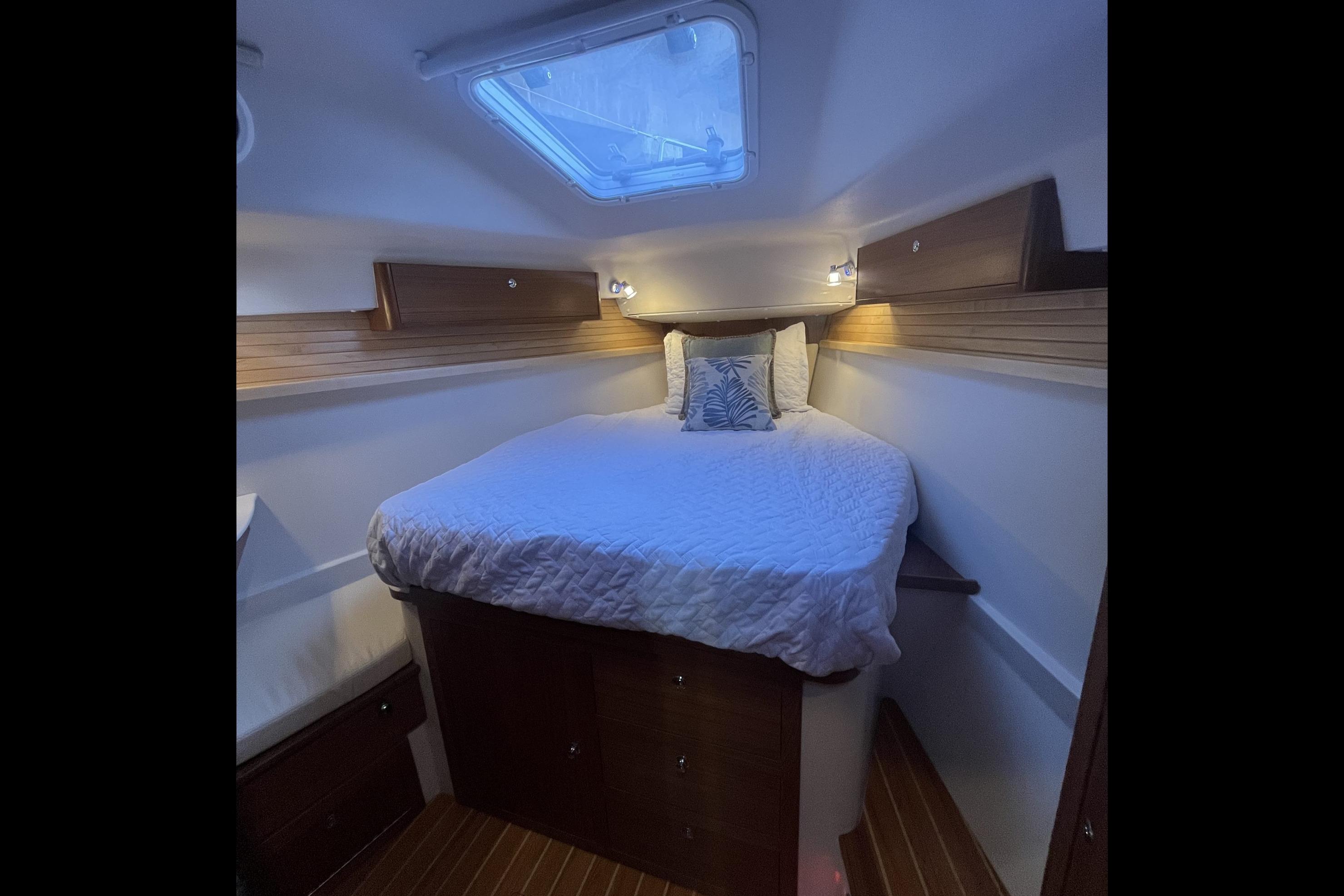 Cozy cabin interior of 2026 Catalina 386 sailboat with skylight and wooden accents.