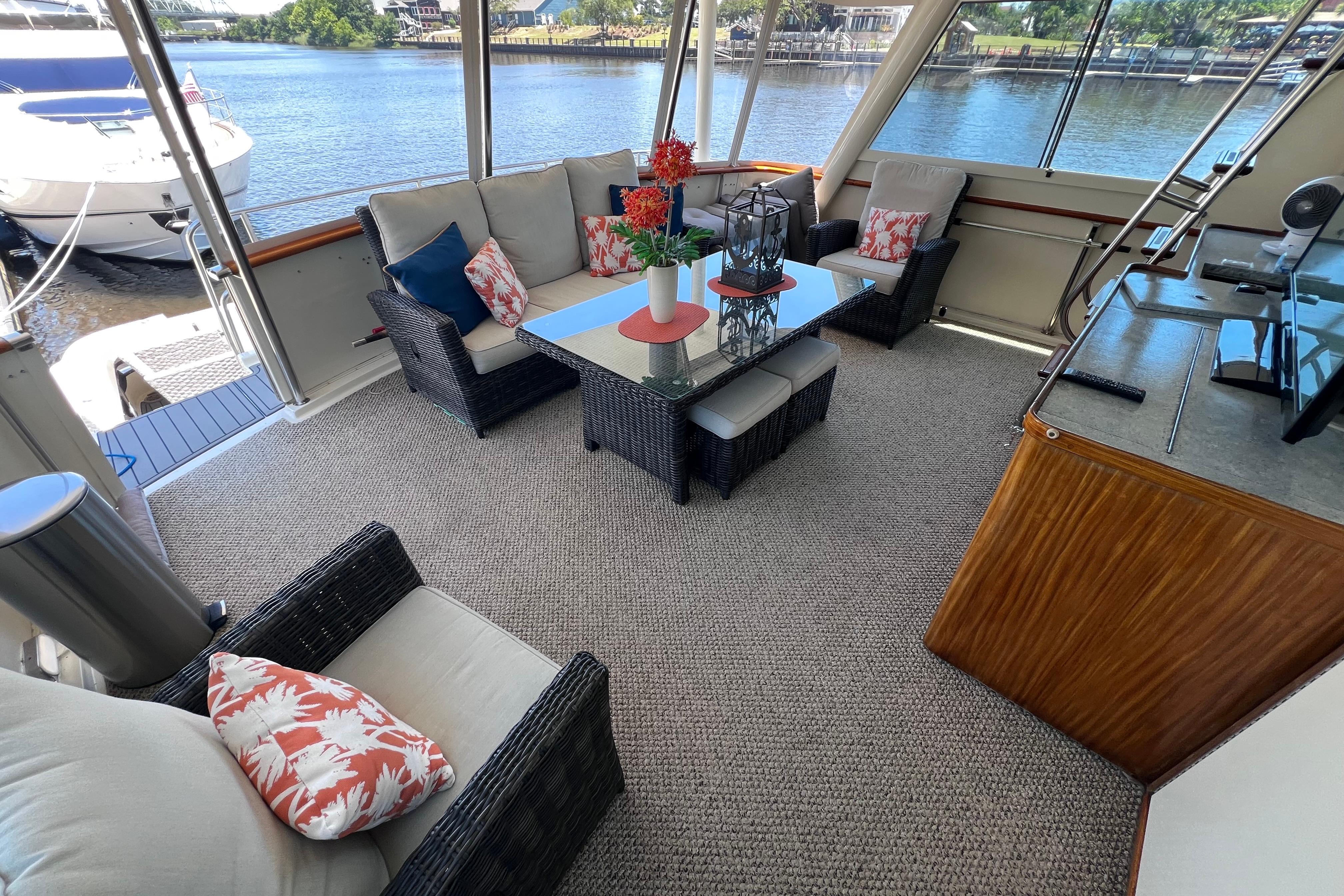 Luxurious 1987 Hatteras 70 Cockpit Motor Yacht interior with elegant seating and waterfront view.