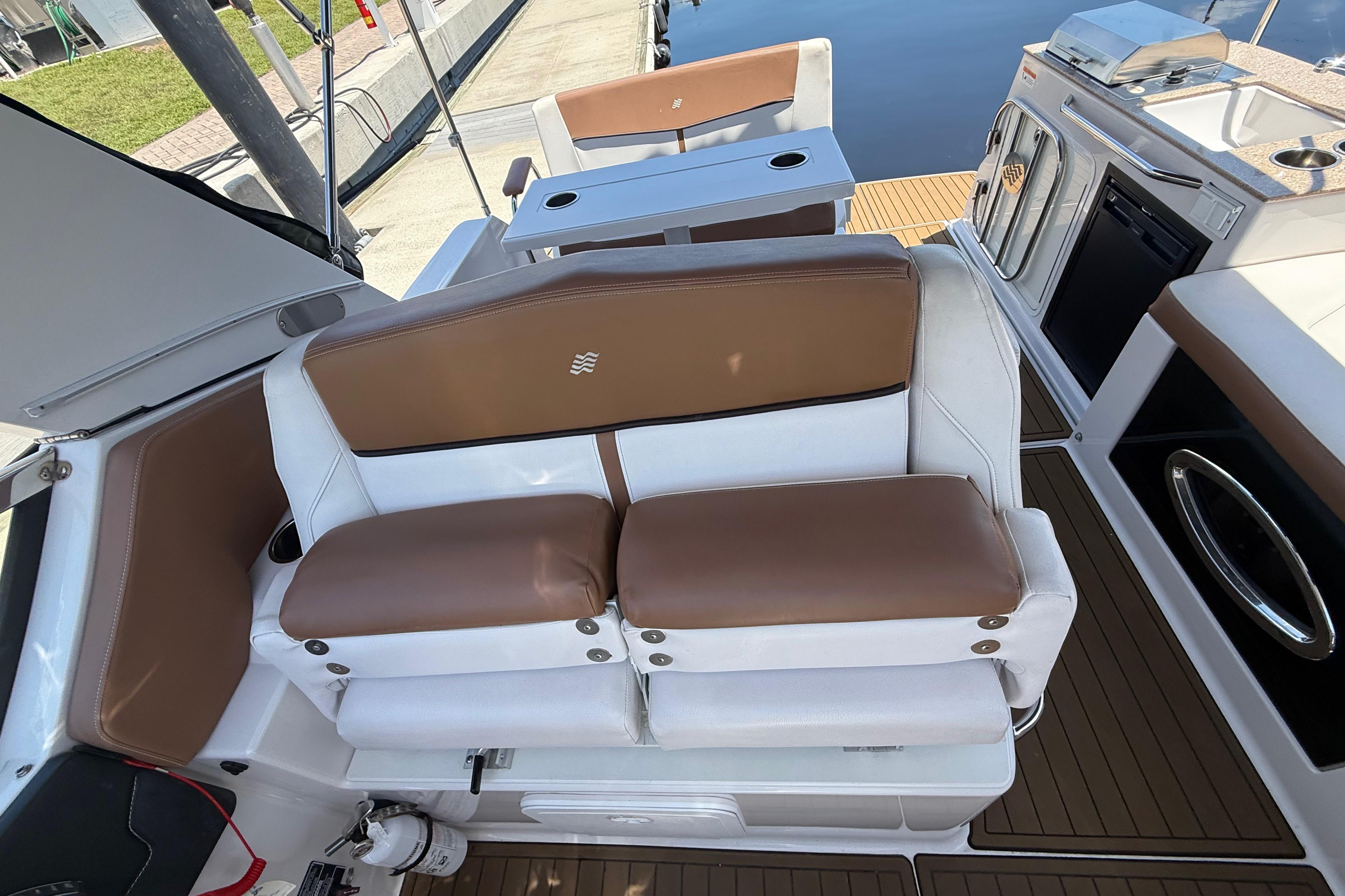 2017 Four Winns V275 boat interior with brown and white seating, kitchenette, and deck.