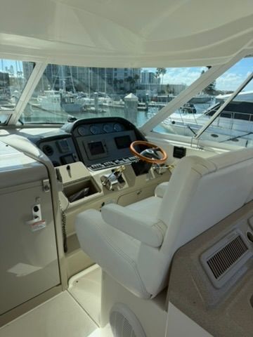 Interior of 2005 Sea Ray 390 Motor Yacht, helm station with marina view.