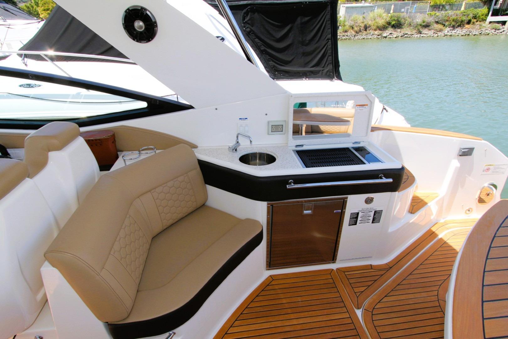 2021 Sea Ray Sundancer 320 Outboard interior with seating and kitchenette on deck.