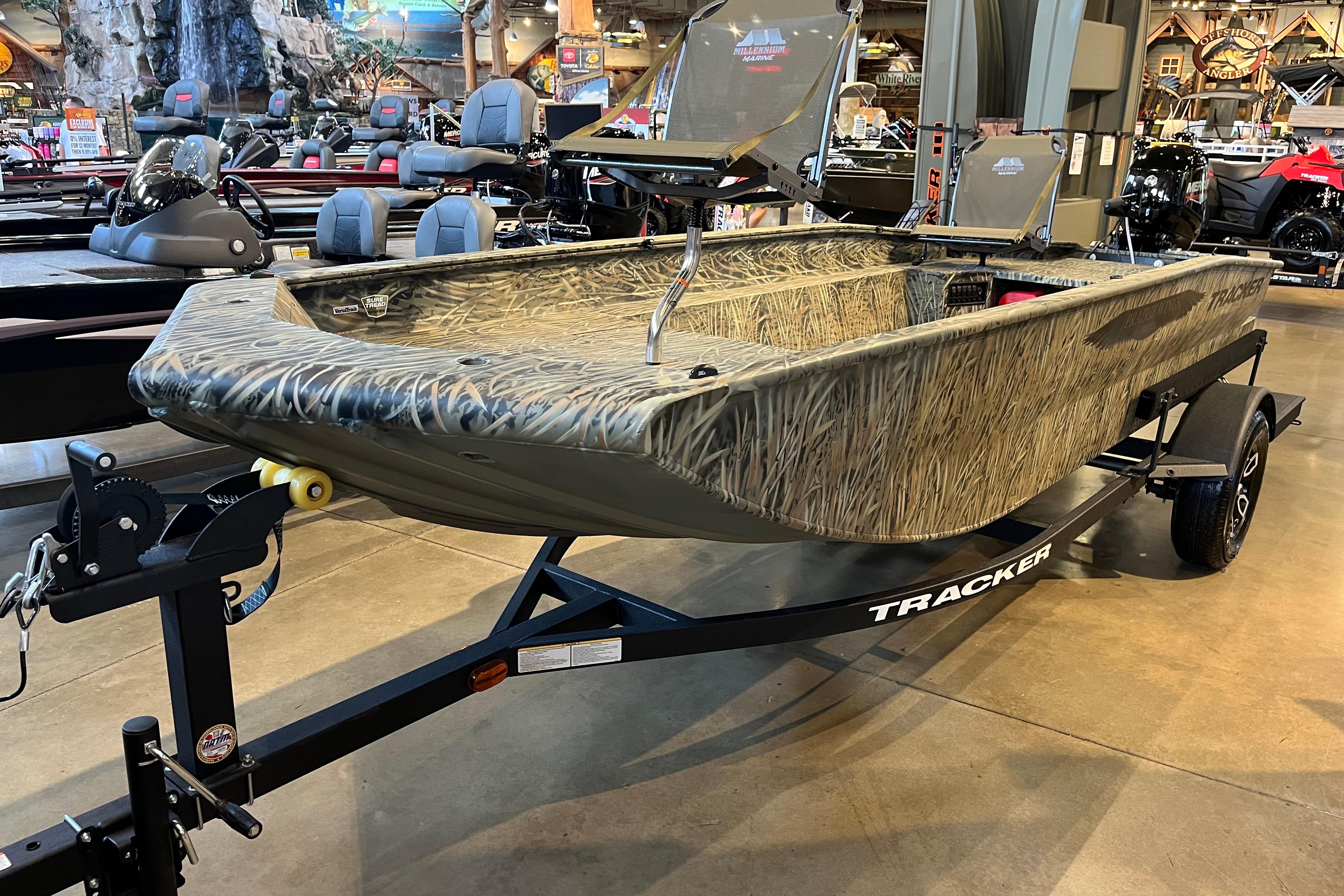 2026 Tracker Grizzly 1654 T Sportsman boat with camouflage design on display in showroom.