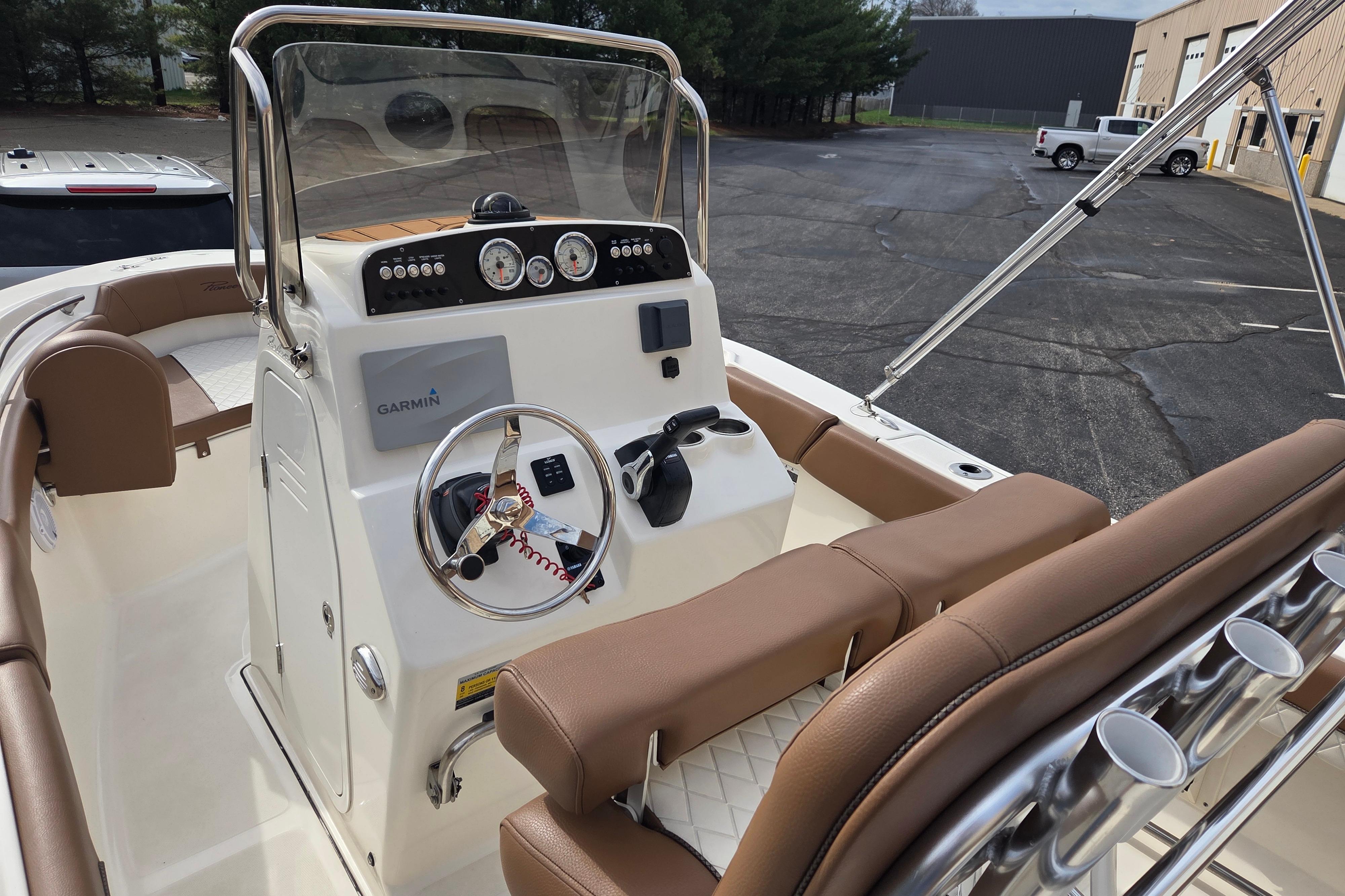 2024 Pioneer 202 Islander boat dashboard with Garmin navigation and brown seating.
