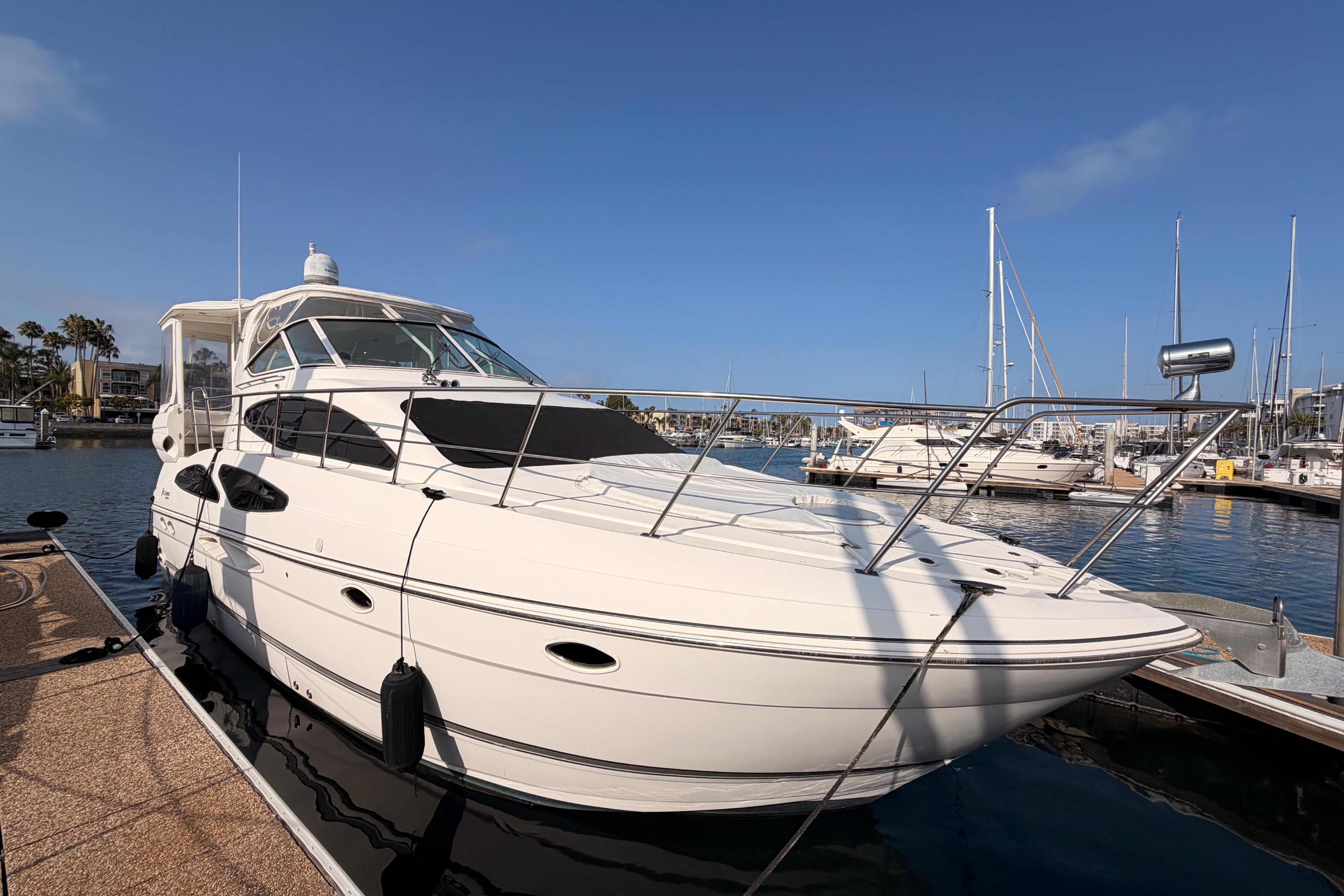 2005 Cruisers Yachts 405 Express Motoryacht docked in a marina under clear blue skies.