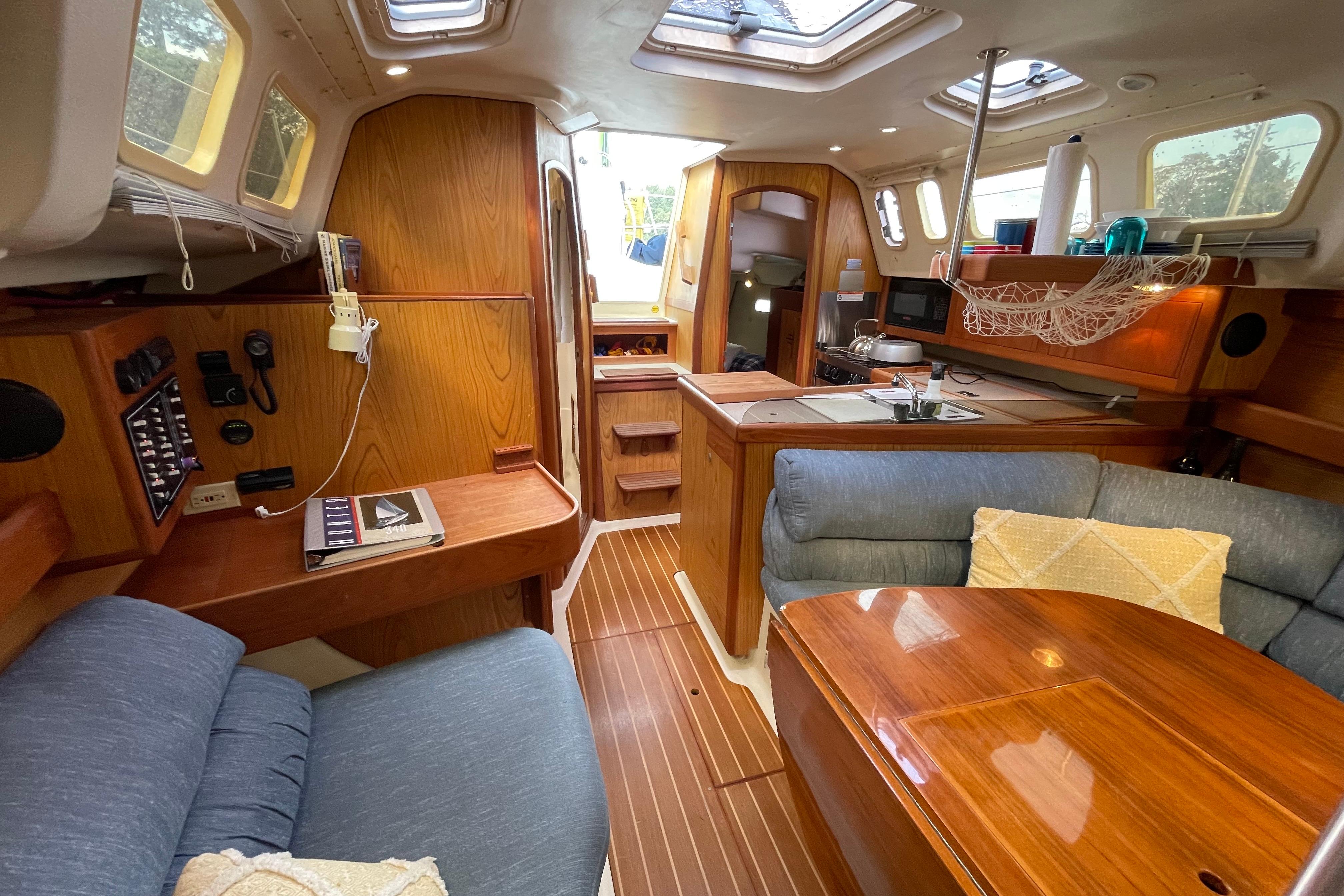 Interior of a 2000 Hunter 340 sailboat with wood finish and cozy seating area.