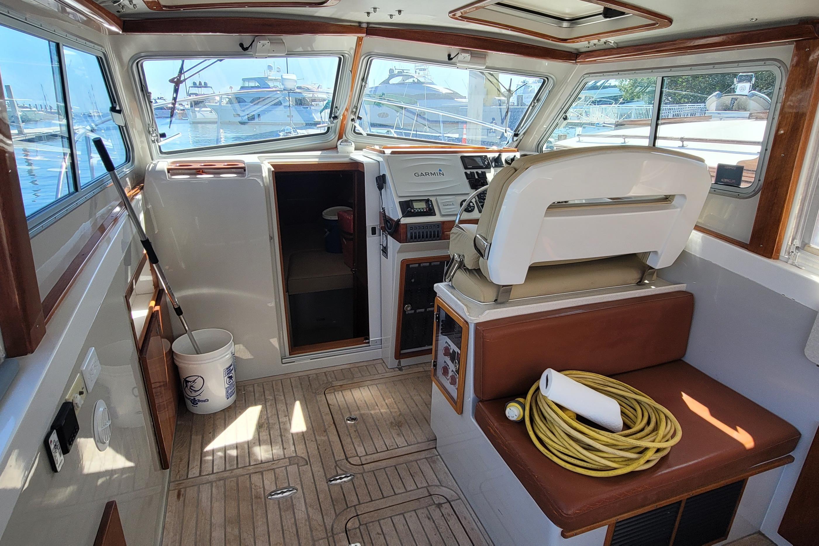 Interior of a 2015 Eastport 32 OBX boat with helm, seating, and nautical equipment.