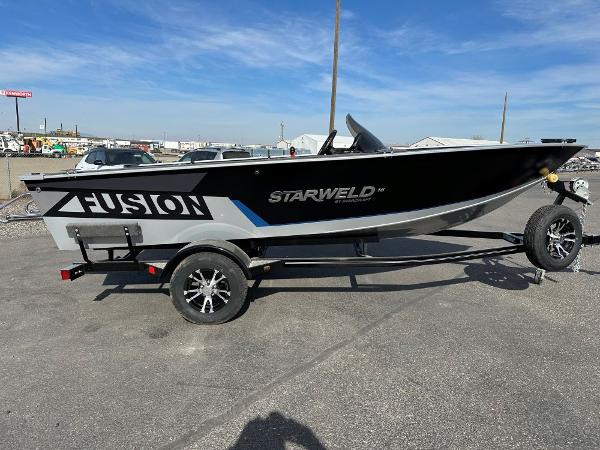 2024 Starweld 16 Fusion SC Pro boat on a trailer in a parking lot.