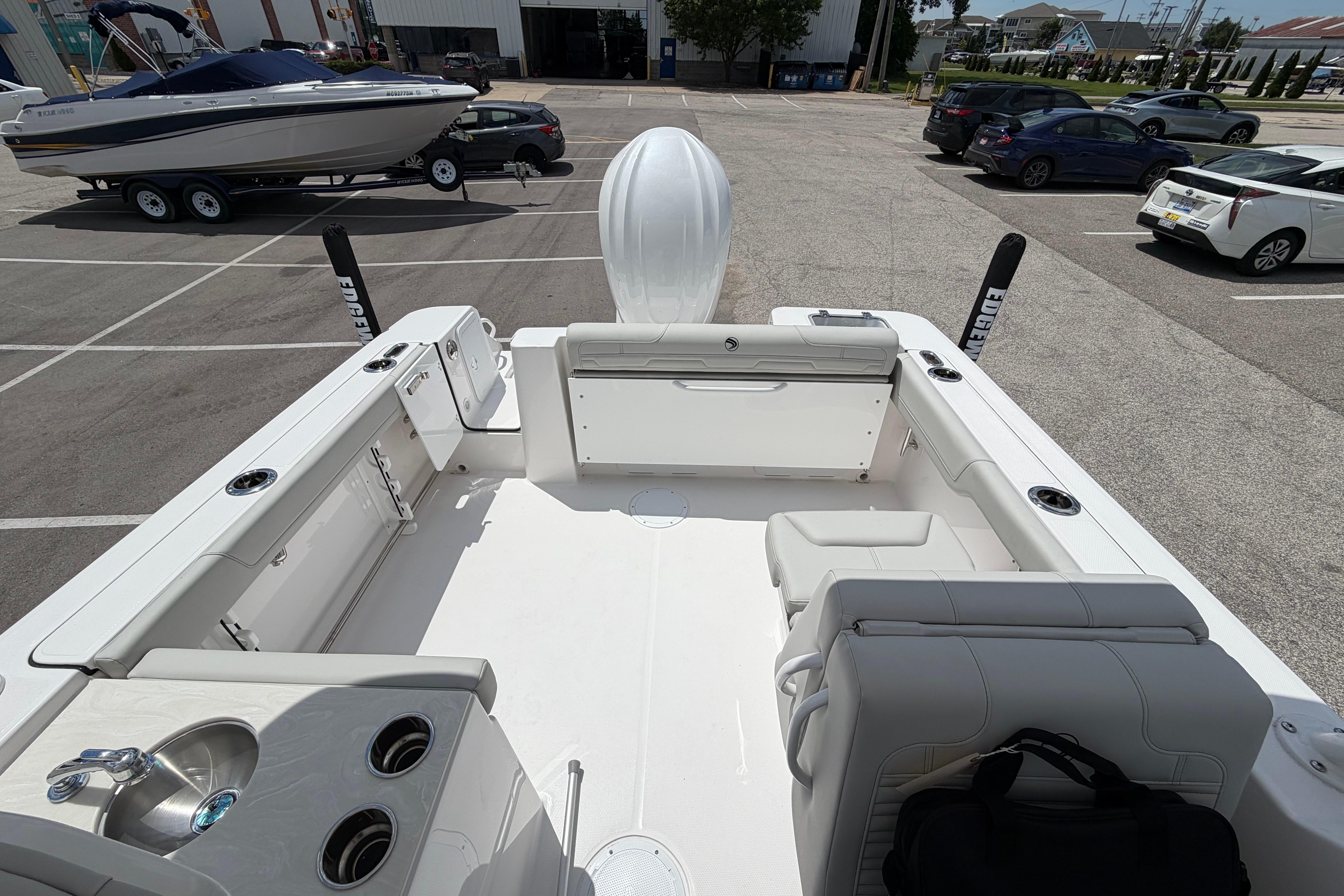 2026 Edgewater 248CX Crossover boat interior with seating and sink in a parking lot.