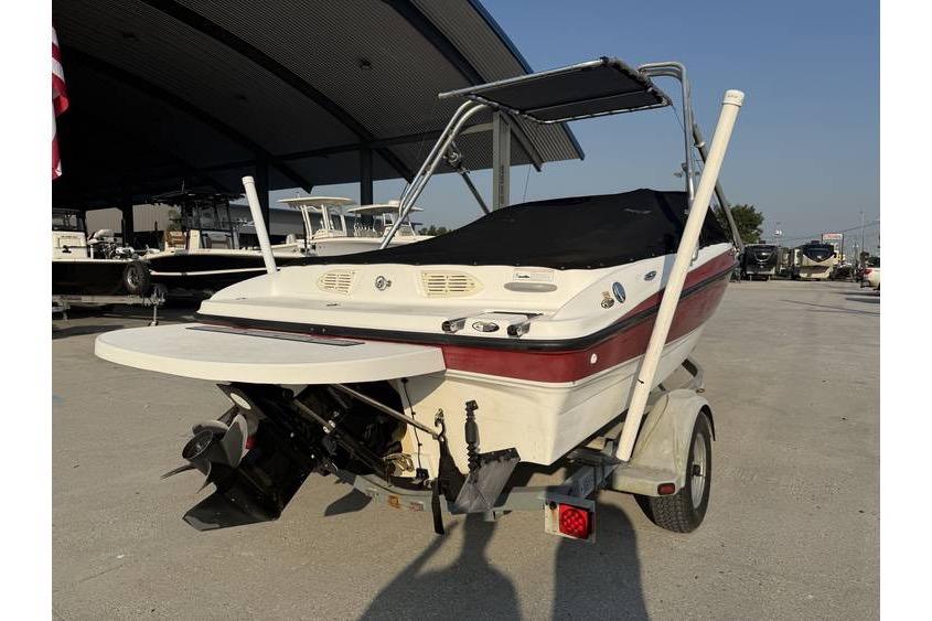 2008 Bayliner 185 Bowrider boat on trailer, rear view, under a canopy.
