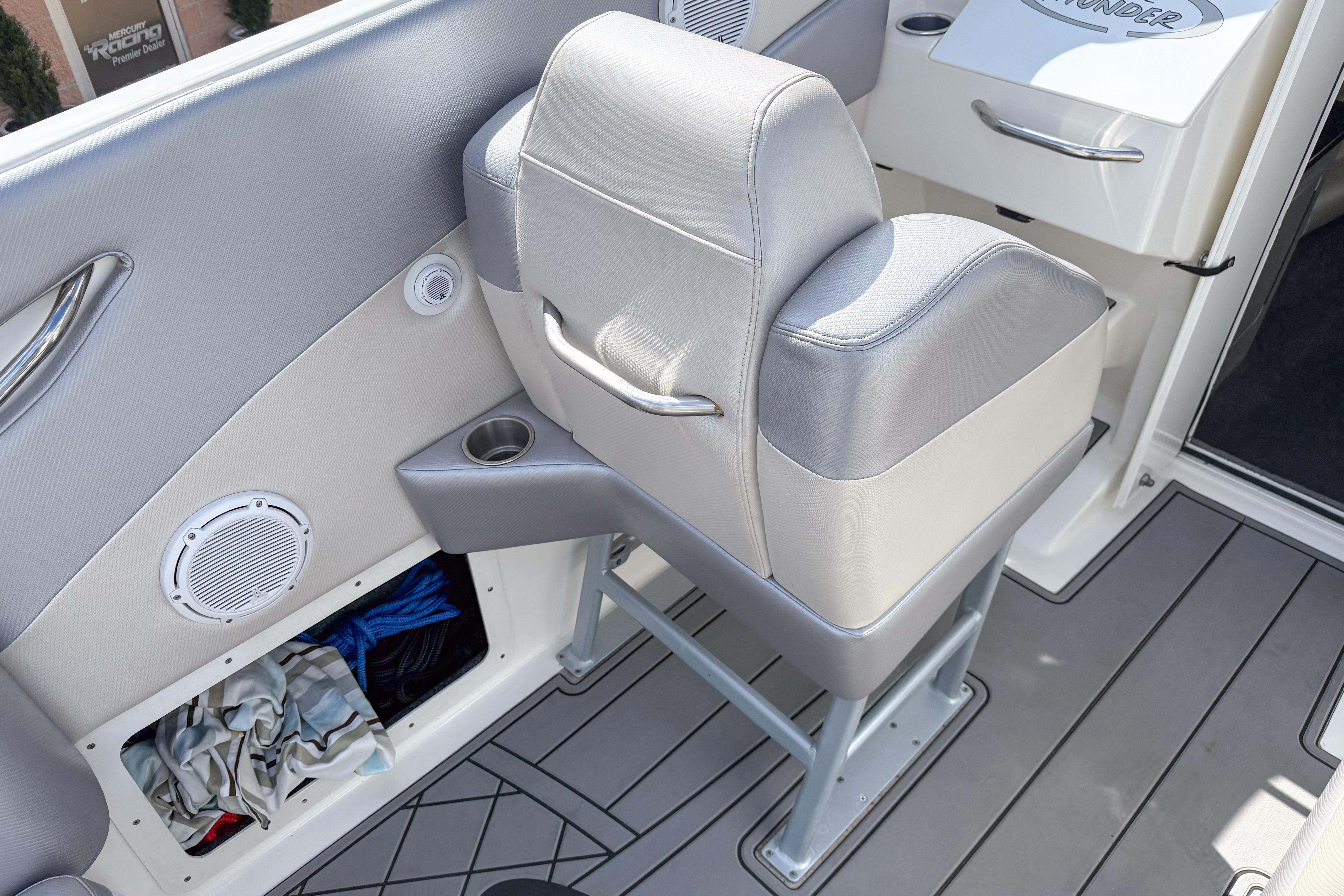 Interior of a 2002 Active Thunder 37 boat featuring a cushioned seat and storage compartment.