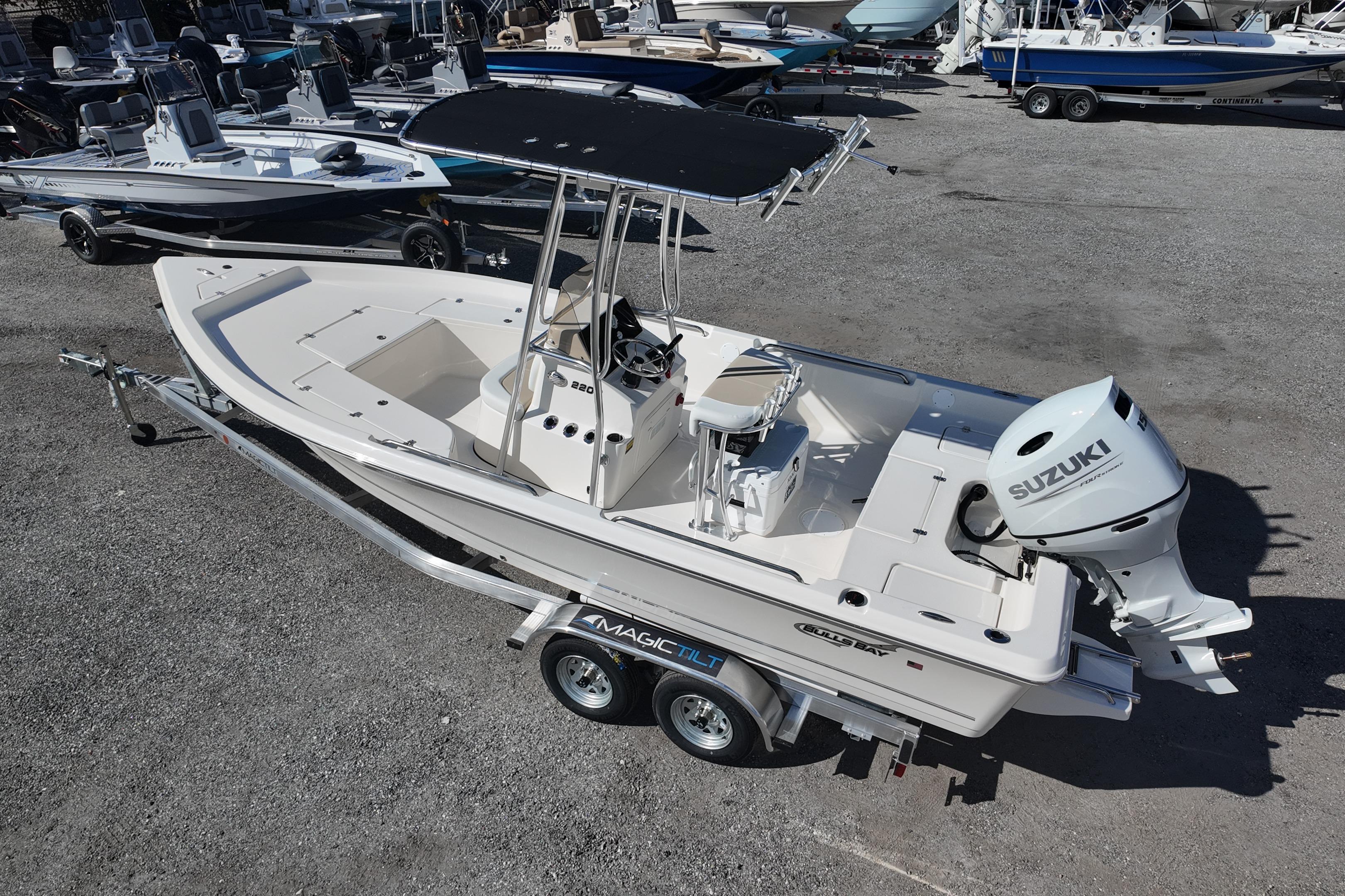 2026 Bulls Bay 2200 boat on trailer with Suzuki outboard motor in a marina setting.
