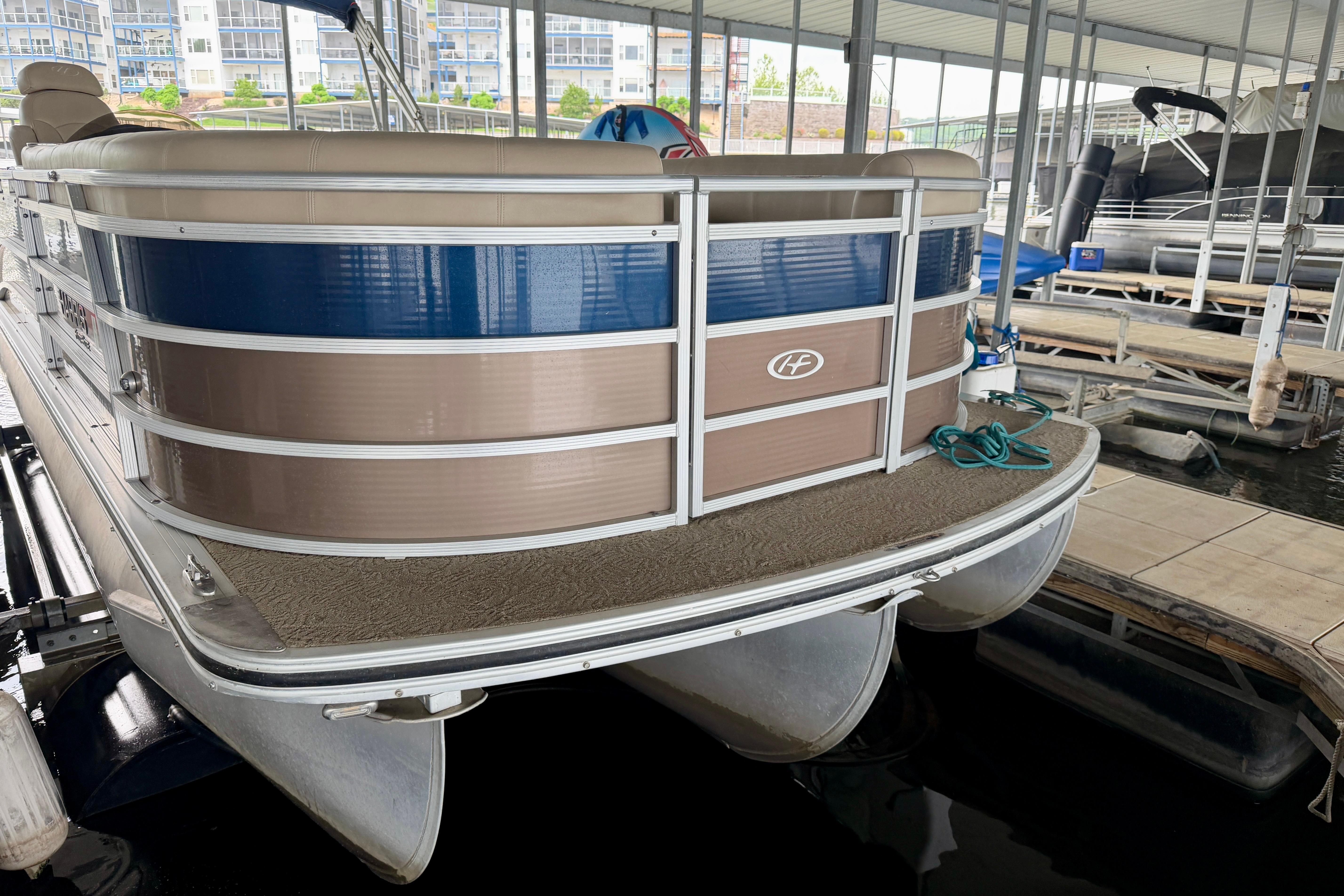 2013 Harris Solstice 240 pontoon boat docked in a marina.