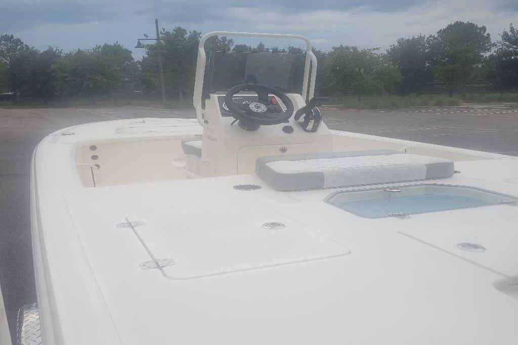 2026 Mako 18 Pro Skiff boat with center console and seating, parked outdoors.