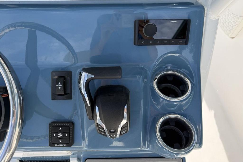 Control panel of 2026 Tidewater 232 LXF boat with steering wheel and cup holders.