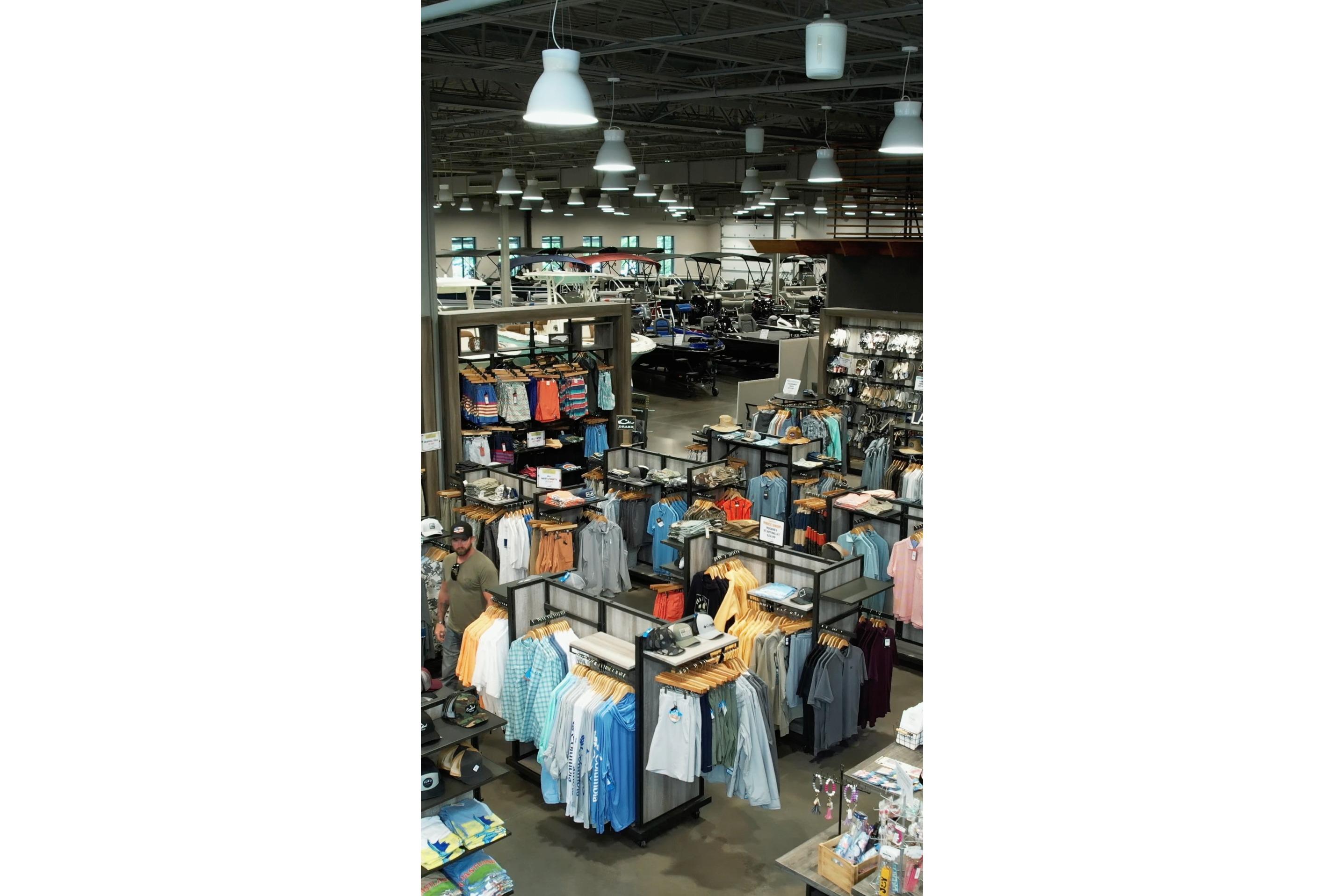 Clothing store interior with 2026 Bass Cat Cougar FTD SP boat in background.
