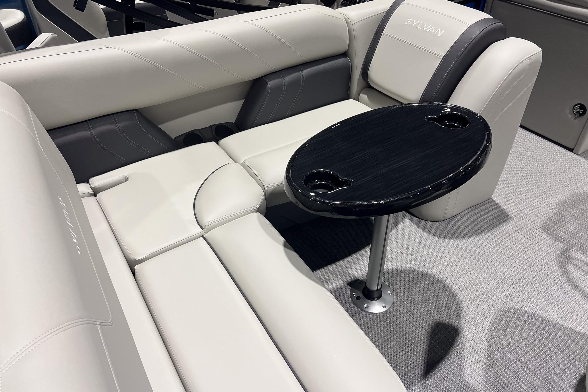 2026 Sylvan Mirage 822 CLZ boat interior with plush seating and a sleek black table.
