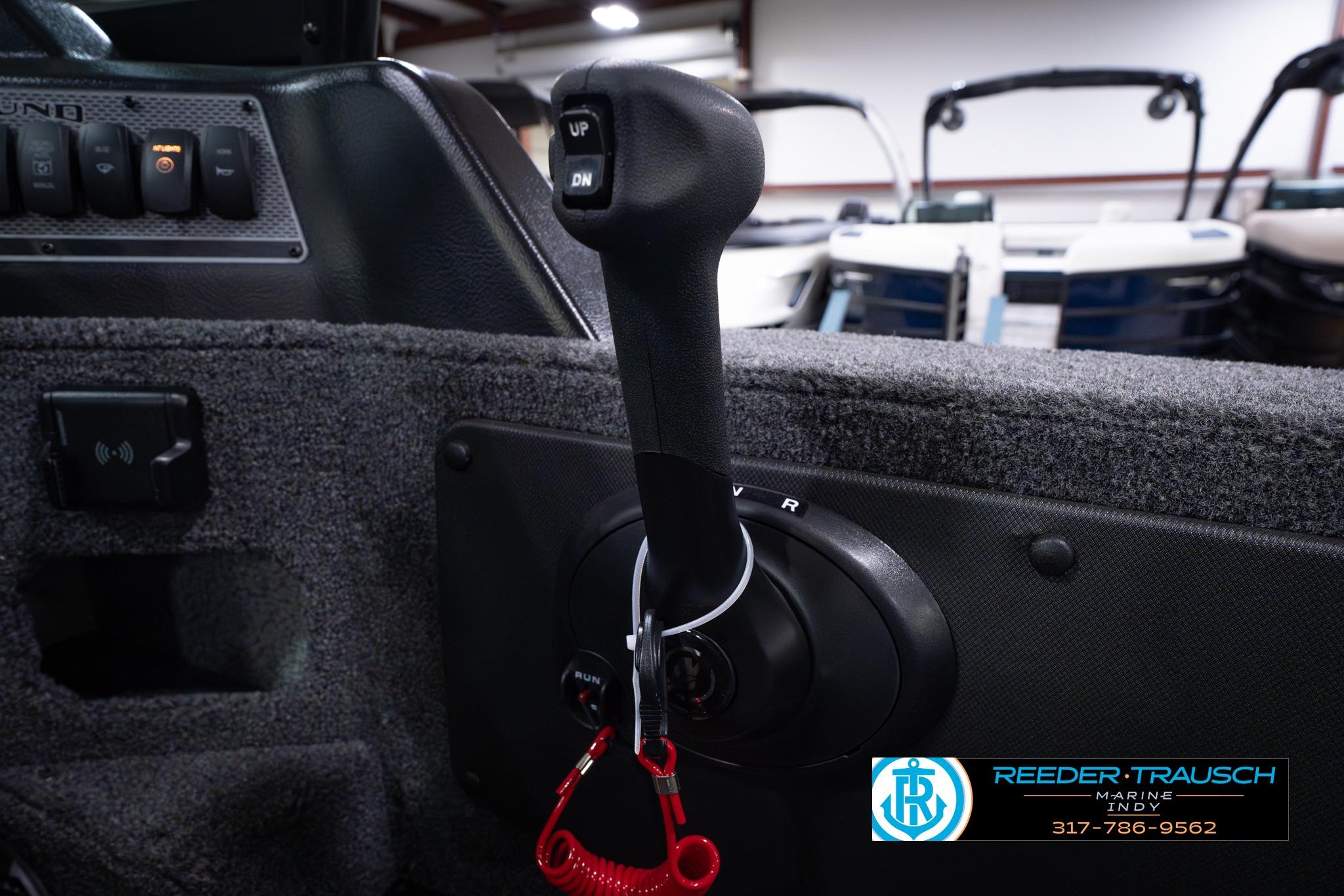 2026 Lund 1875 Impact XS SS boat throttle control with safety lanyard in showroom.
