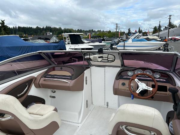 2010 Cobalt 262 boat interior with steering wheel and dashboard, docked among other boats.