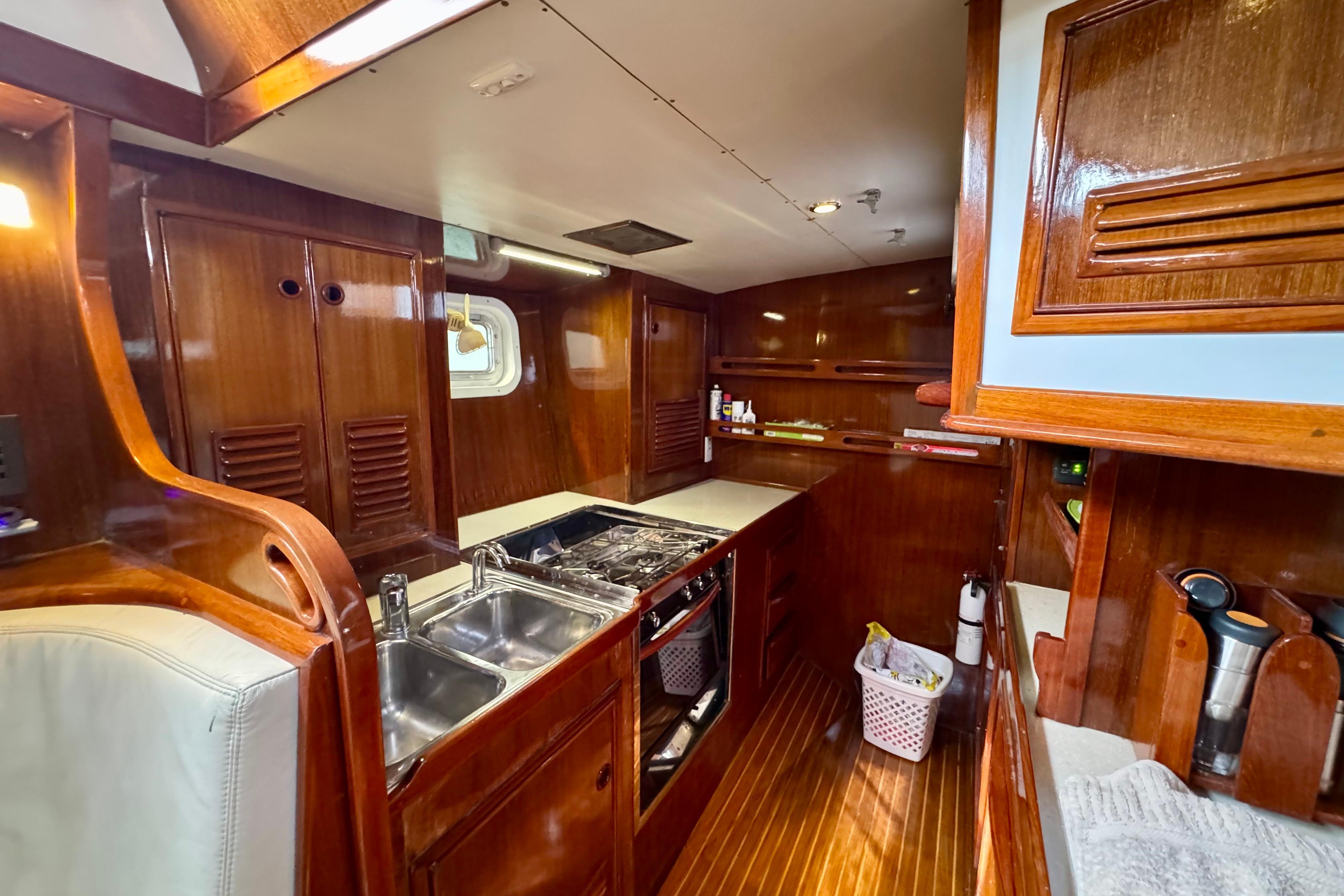 Luxurious wooden interior of 1981 Ron Holland 52 yacht kitchen with modern amenities.