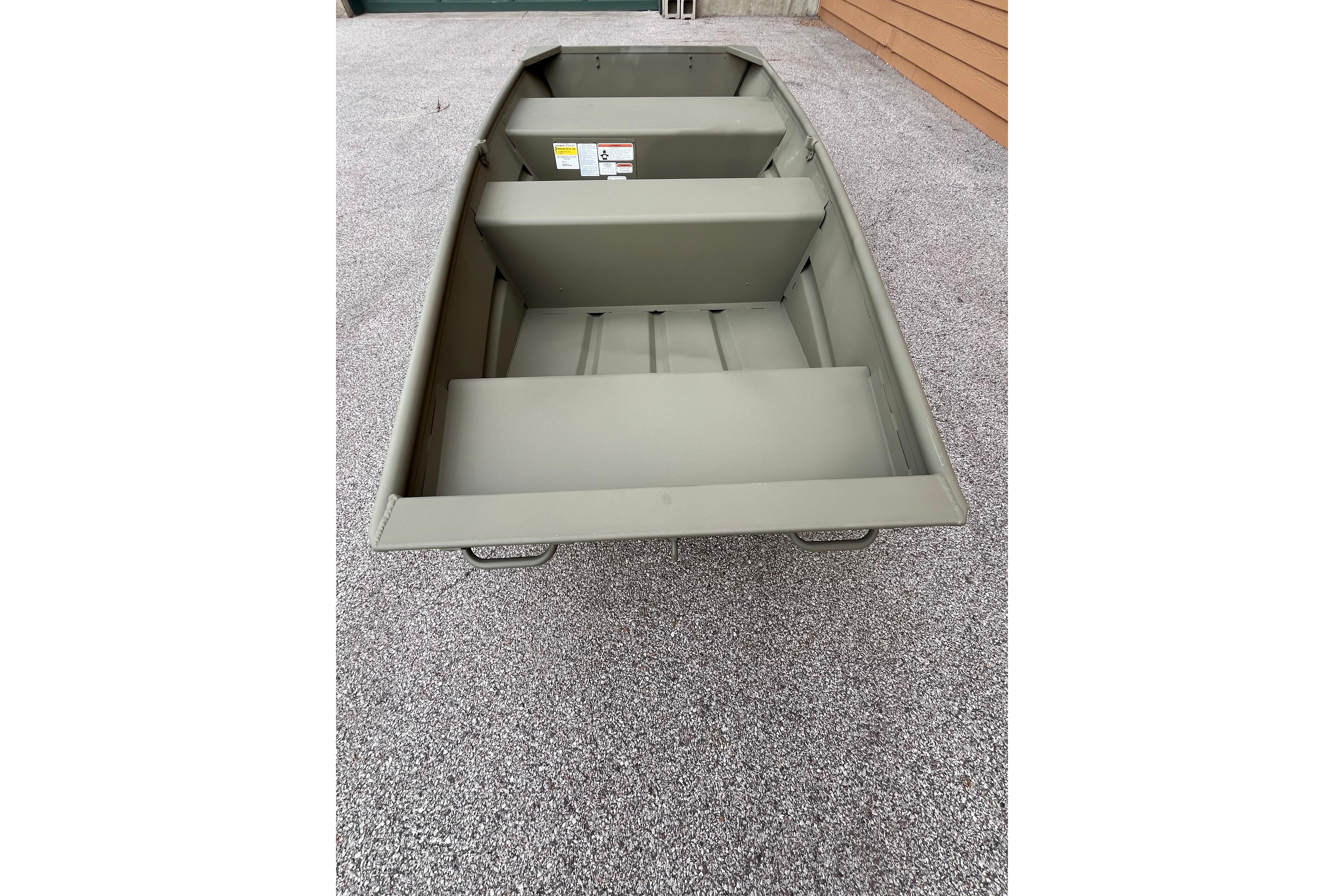 2026 Tracker Grizzly 10 Jon boat on gravel surface, showcasing interior seating and design.
