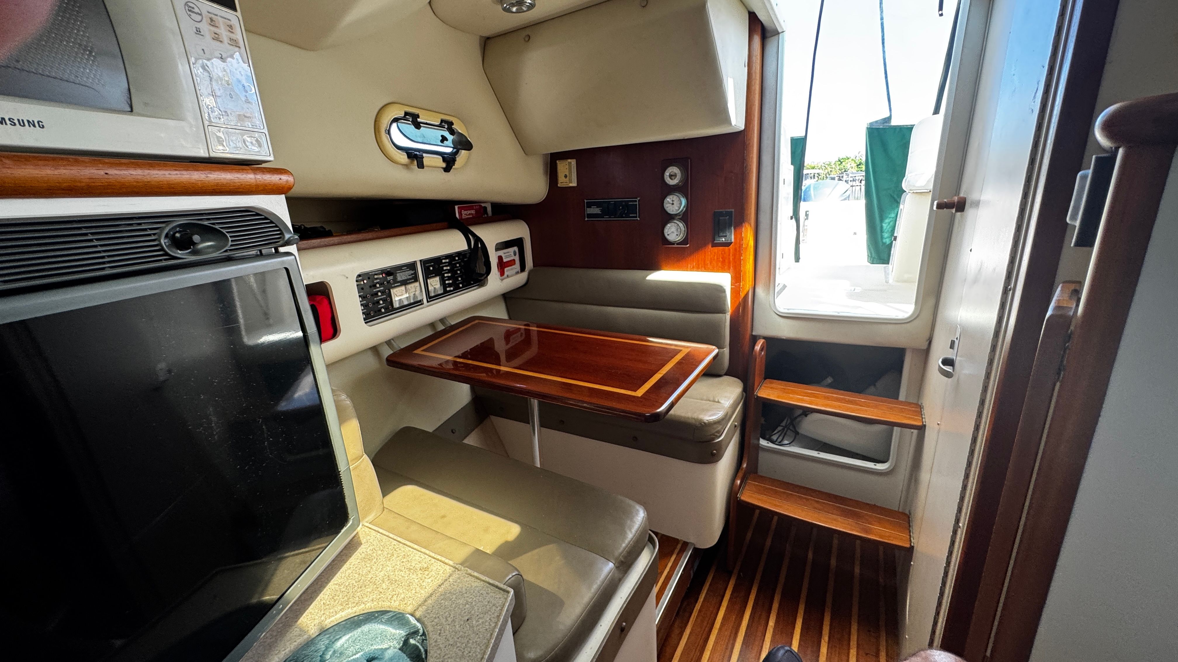 Interior of a 2003 Pursuit 3070 with seating area and table.