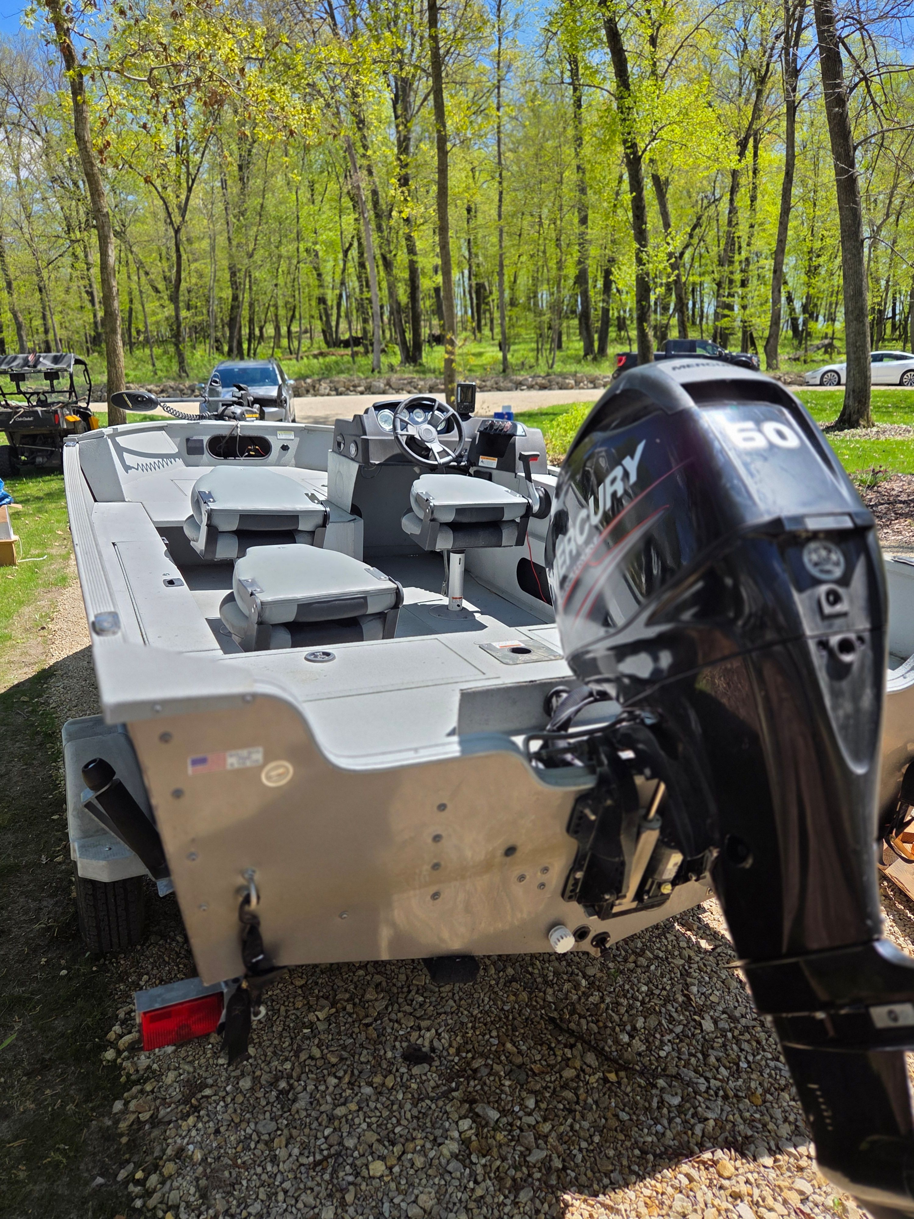 2015 Lowe Fishing Machine 165 Poly Camo with Mercury engine in forest setting.