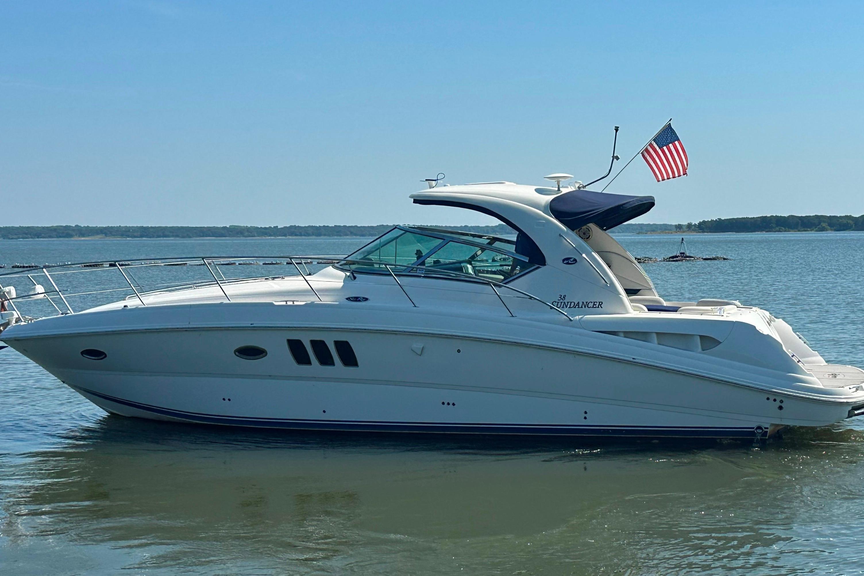 2007 Sea Ray 38 Sundancer yacht on calm water with American flag.